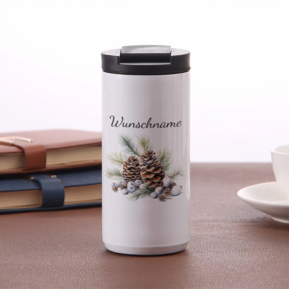 Weißer Thermobecher mit personalisiertem Wunschname und Tannenzapfen-Dekor.