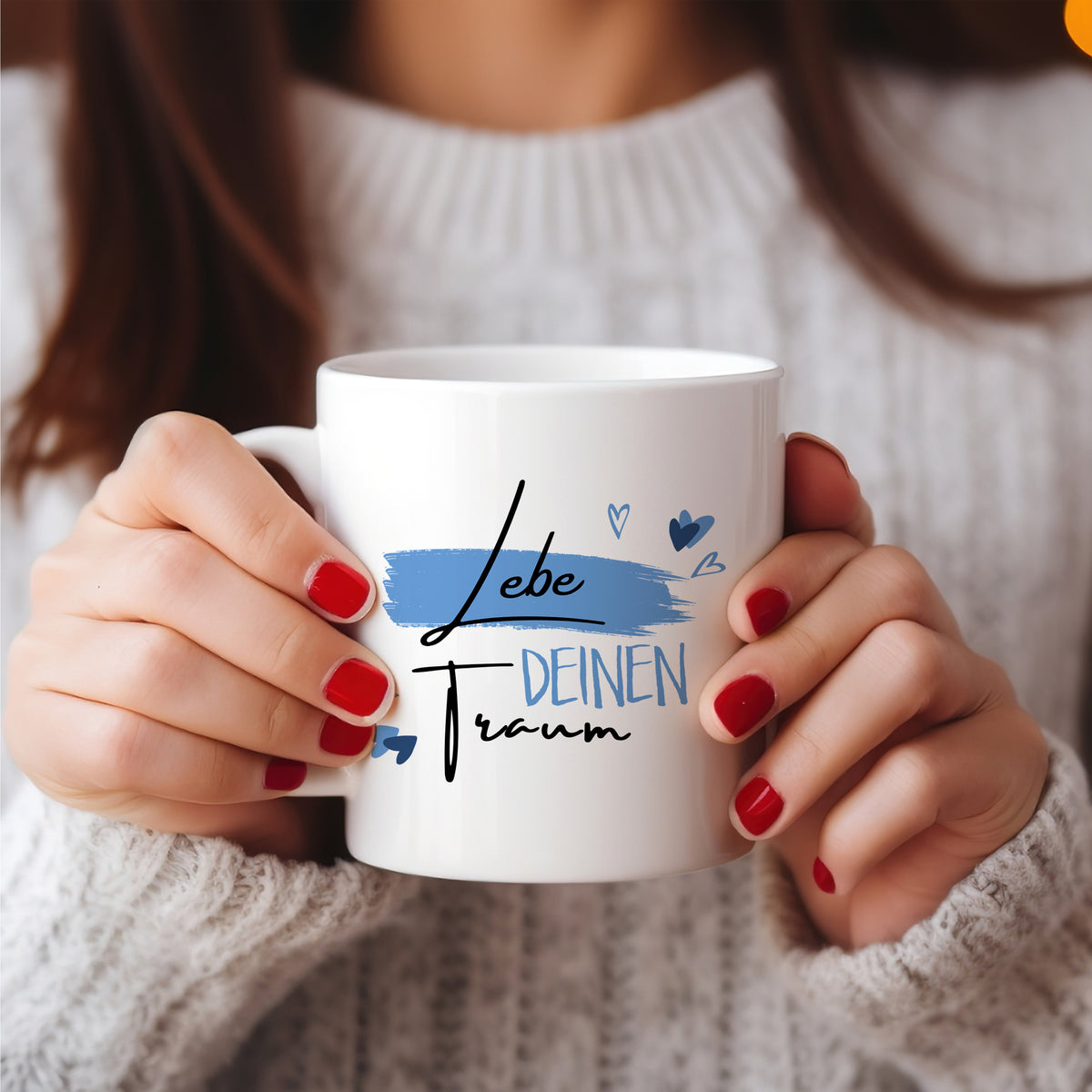 Weiße Tasse mit Aufschrift „Lebe deinen Traum“ in Blau.