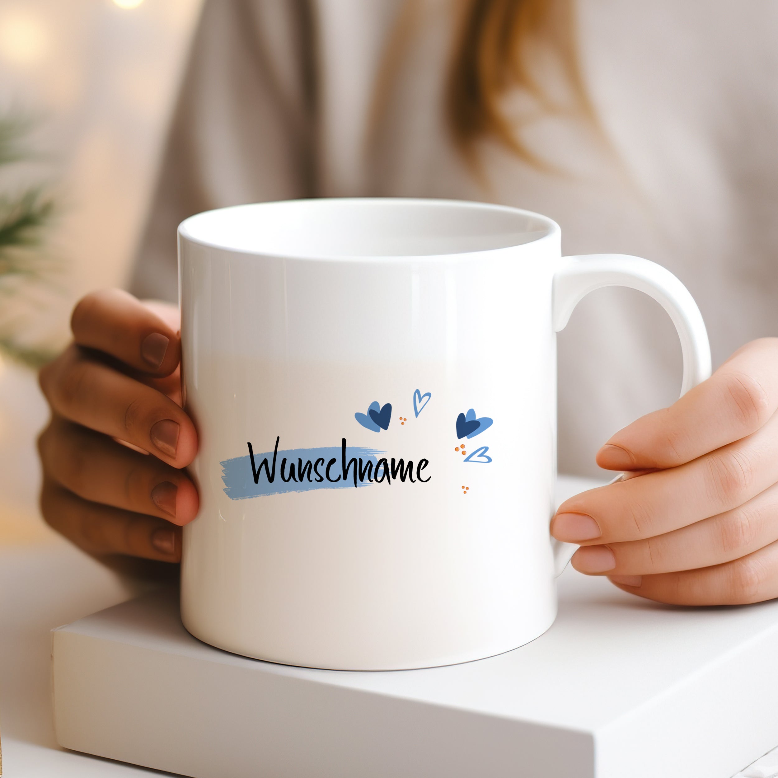 Weißer Becher mit personalisiertem Text und blauen Akzenten.
