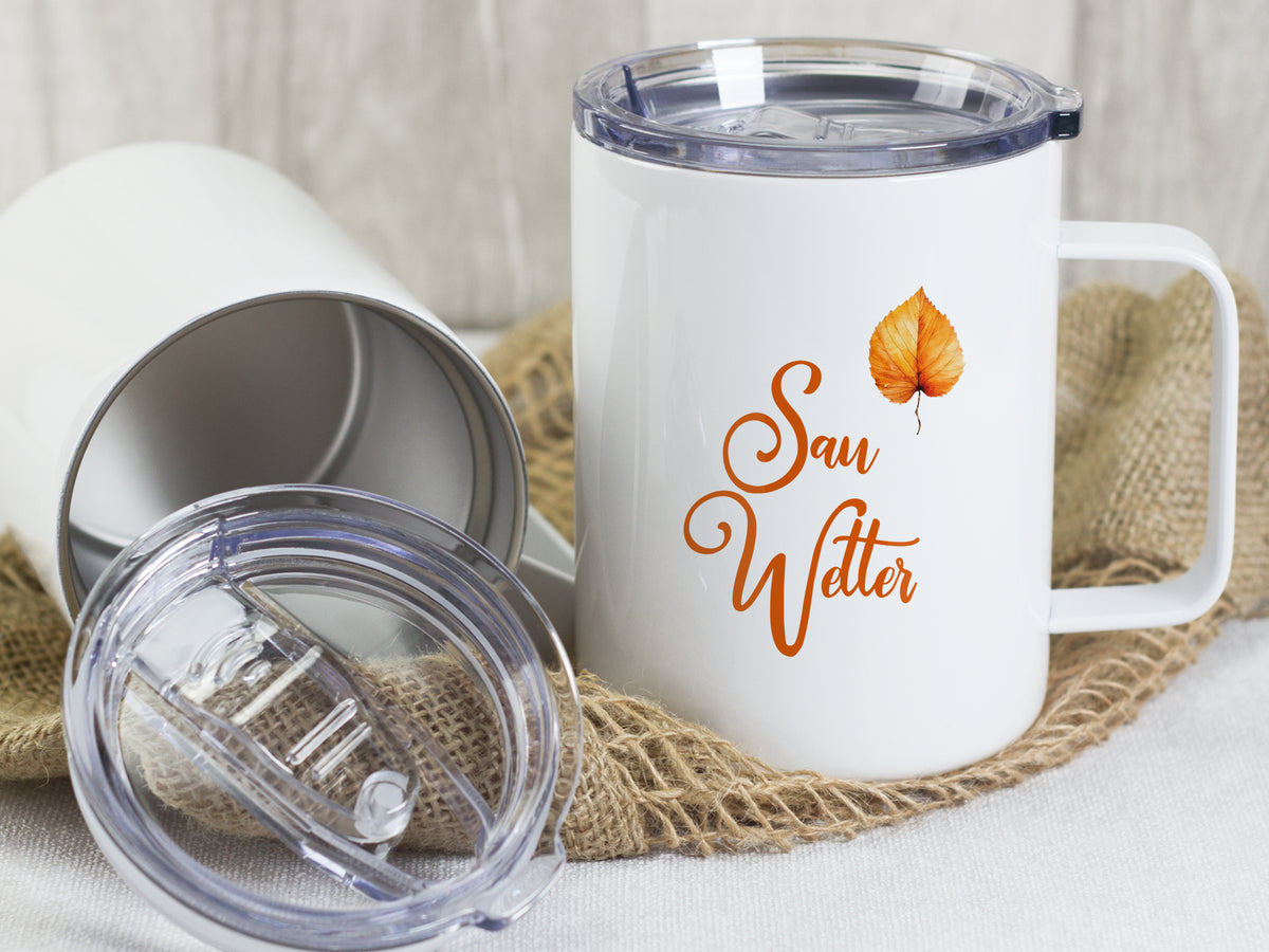 Weißer Becher mit "Sau Wetter"-Aufdruck und orangefarbenem Blatt.