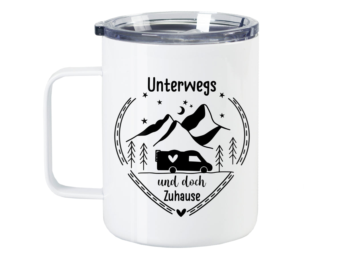 Weißer Becher mit Aufschrift „Unterwegs und doch Zuhause“ und Bergen.