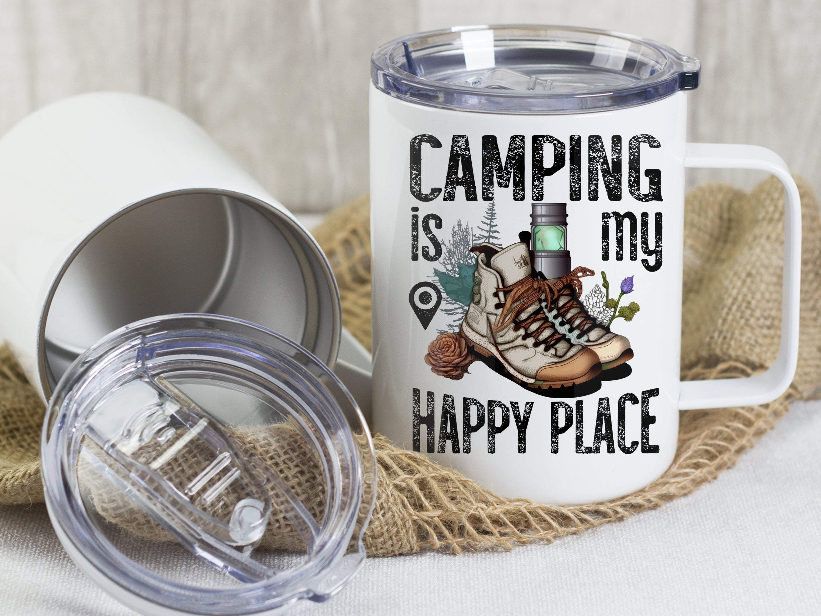 Weißer Becher mit Camping-Motiv und Wanderschuhen.