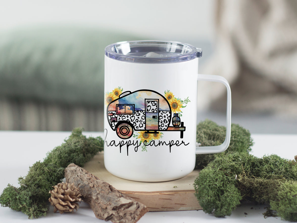 Weißer Becher mit buntem Wohnwagen-Design und "happy camper"-Schriftzug.