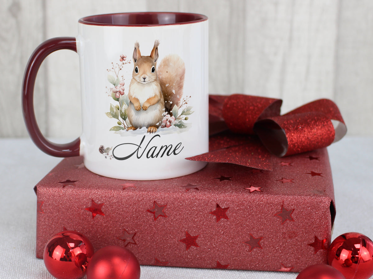 Kaffeetasse mit Eichhörnchen-Motiv und rotem Henkel.
