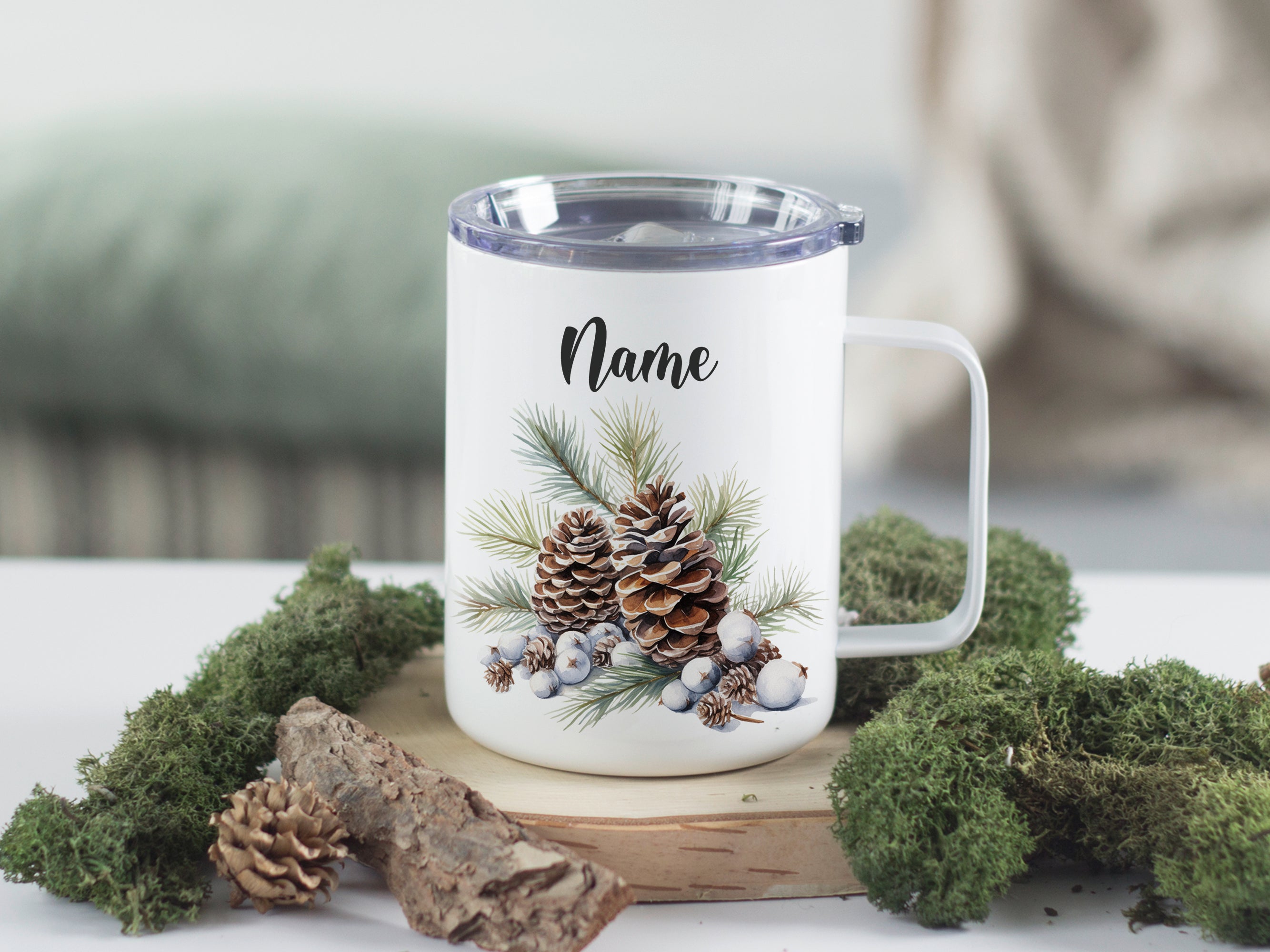 Weißer Becher mit Tannenzapfen und Namen.