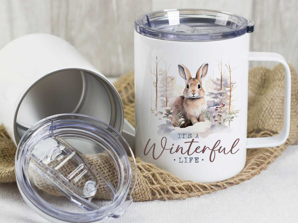 Weißer Becher mit Hasenmotiv und "It's a Winterful Life"-Schriftzug.