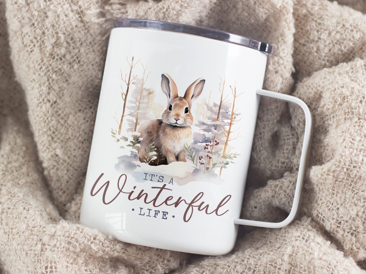 Weißer Becher mit Hasenmotiv und "It's a Winterful Life"-Schriftzug.