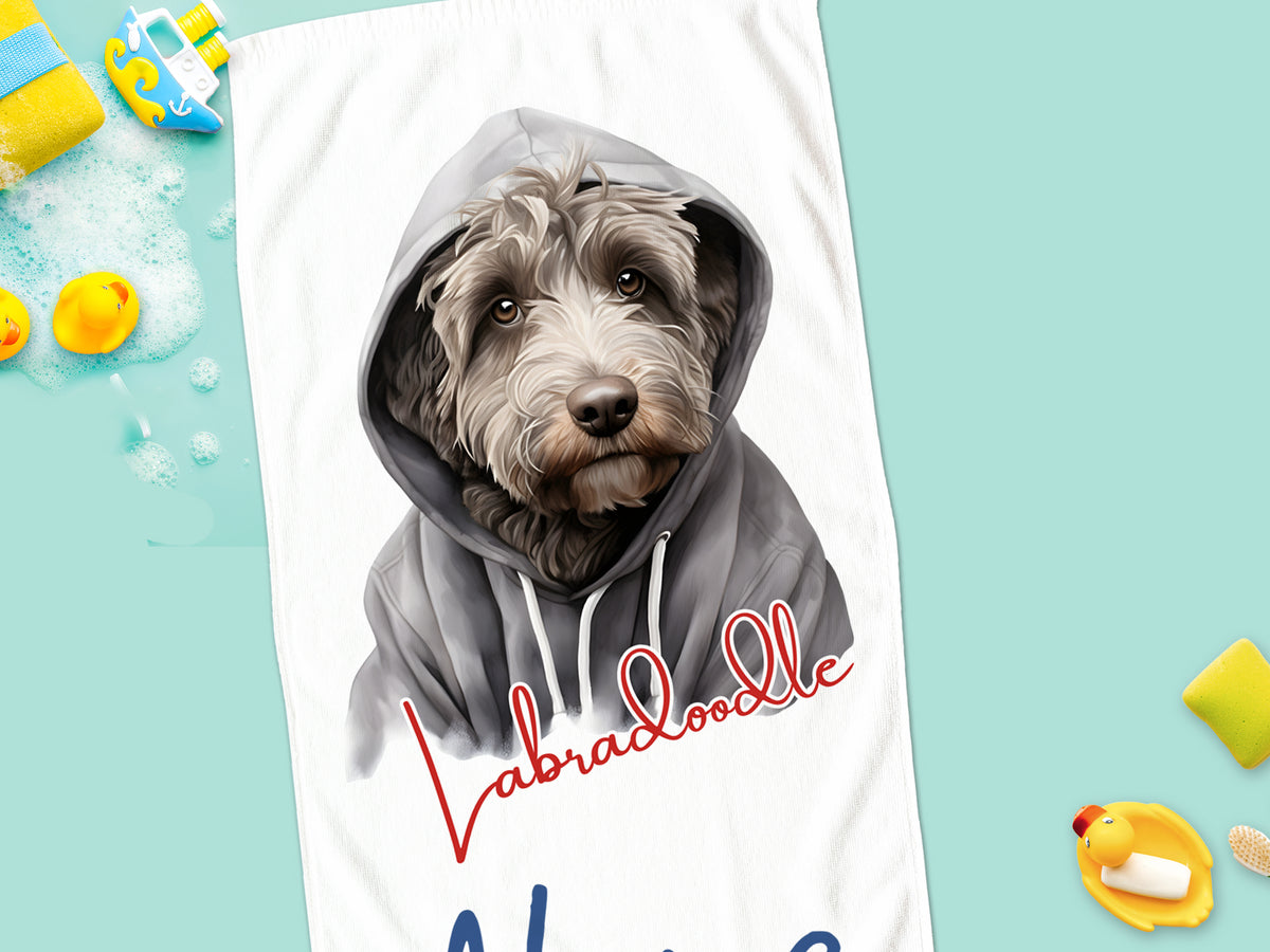 Labradoodle mit Hoodie auf Handtuch, farbenfroh gestaltet.