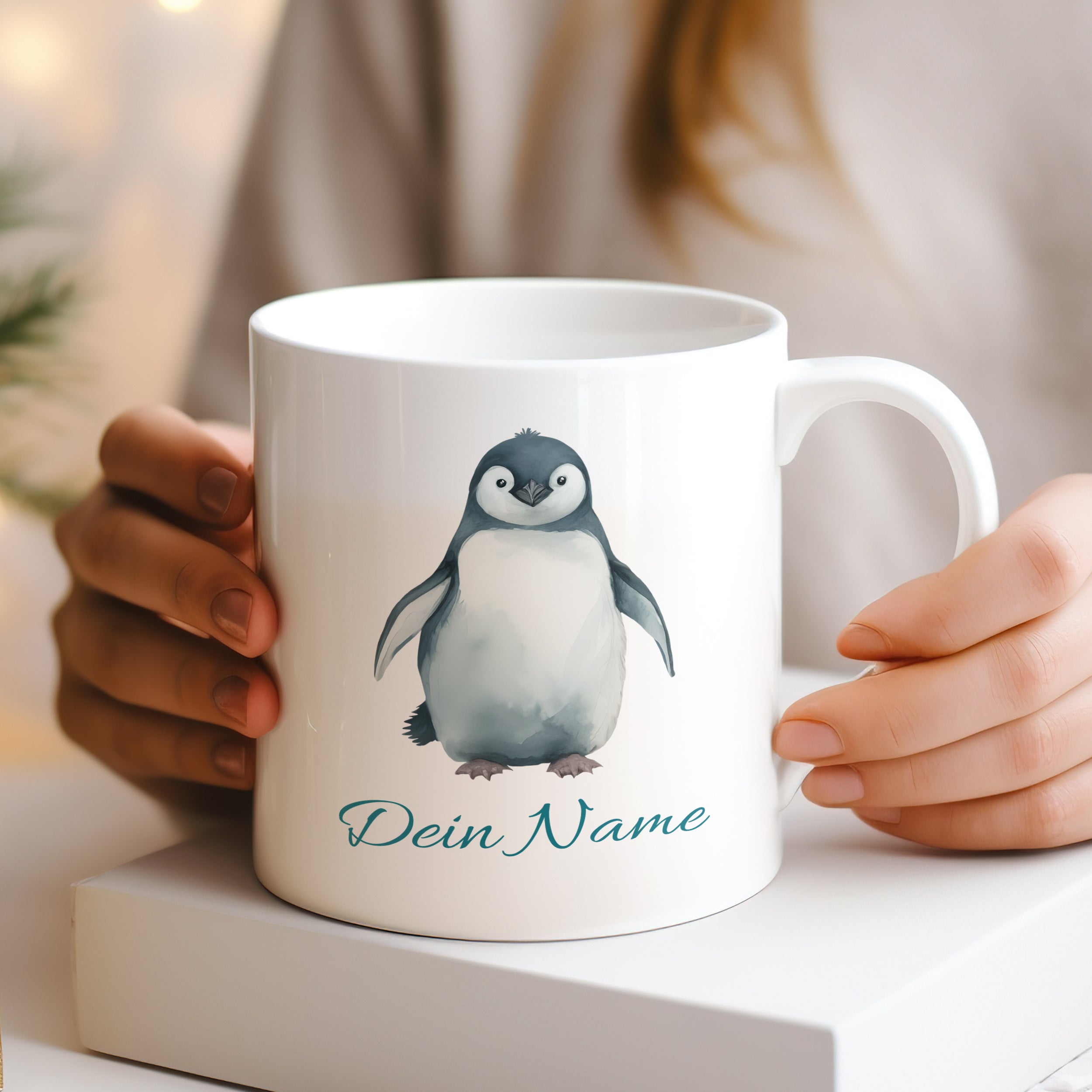 Weißer Becher mit Pinguin-Motiv und personalisiertem Namen.