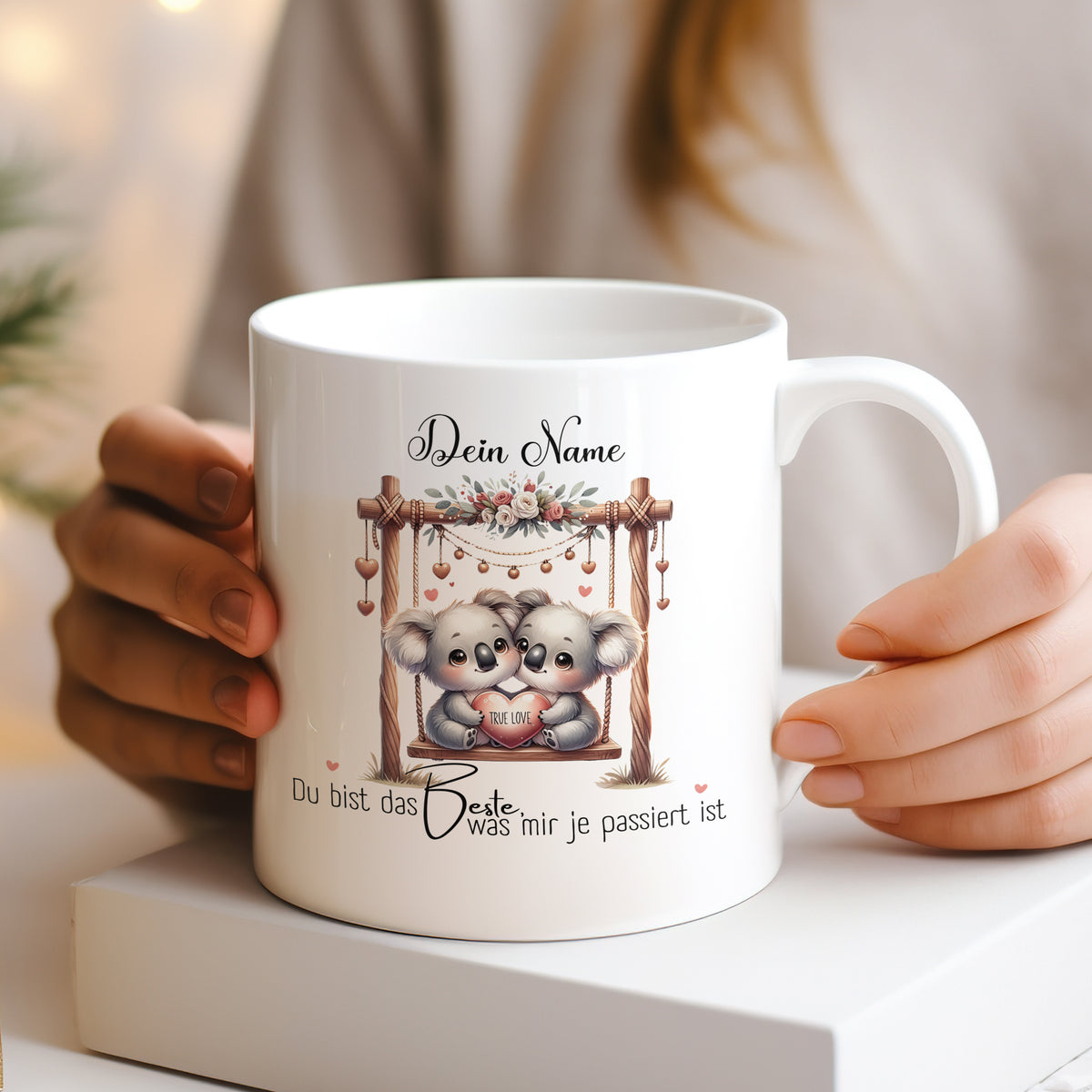Weißer Kaffeebecher mit niedlichen Koalas und persönlicher Botschaft.