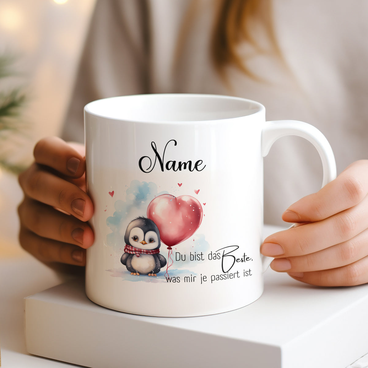 Weißer Becher mit Pinguin und Herzballon, personalisierbar.