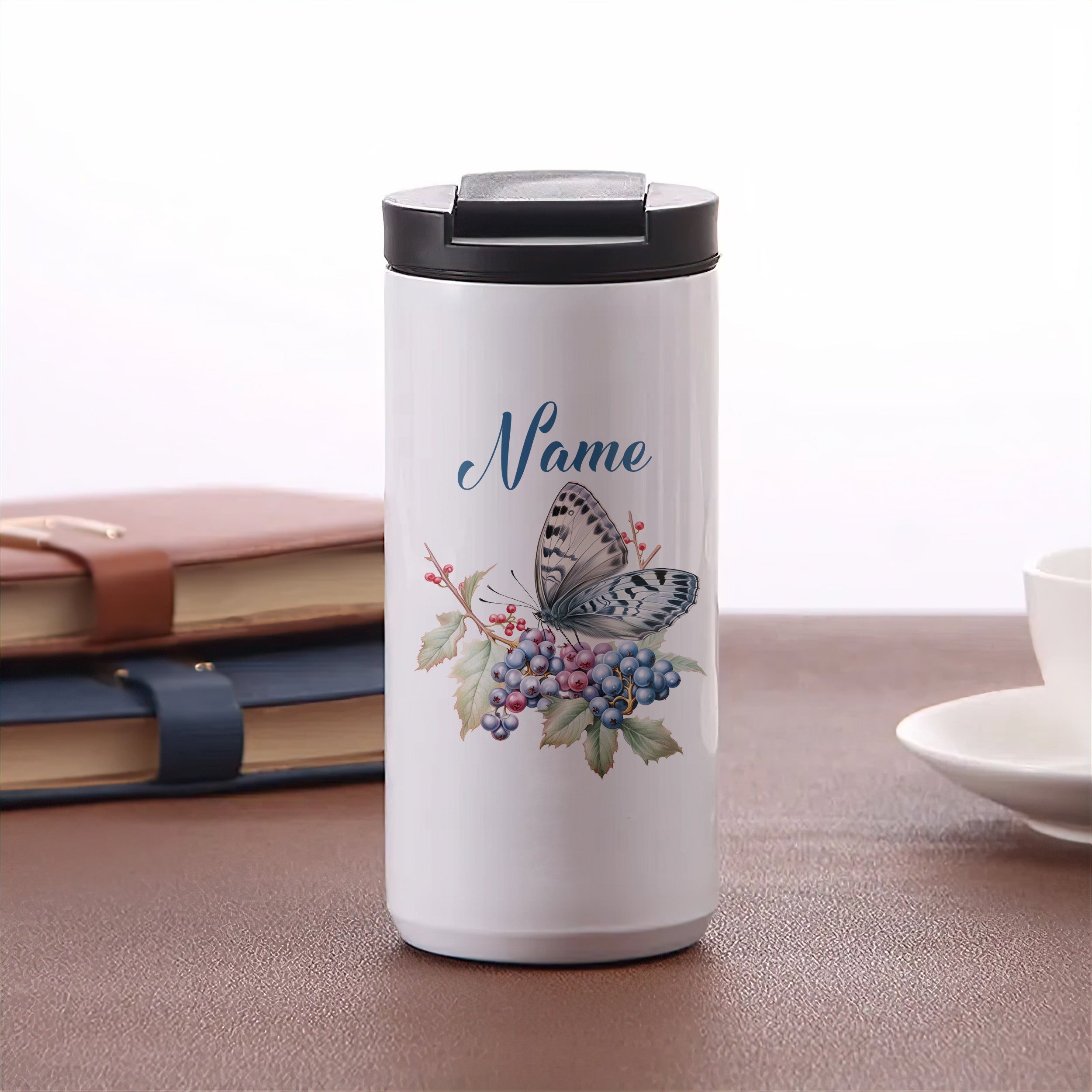 Weißer Thermobecher mit Schmetterling und Traubenmotiv.