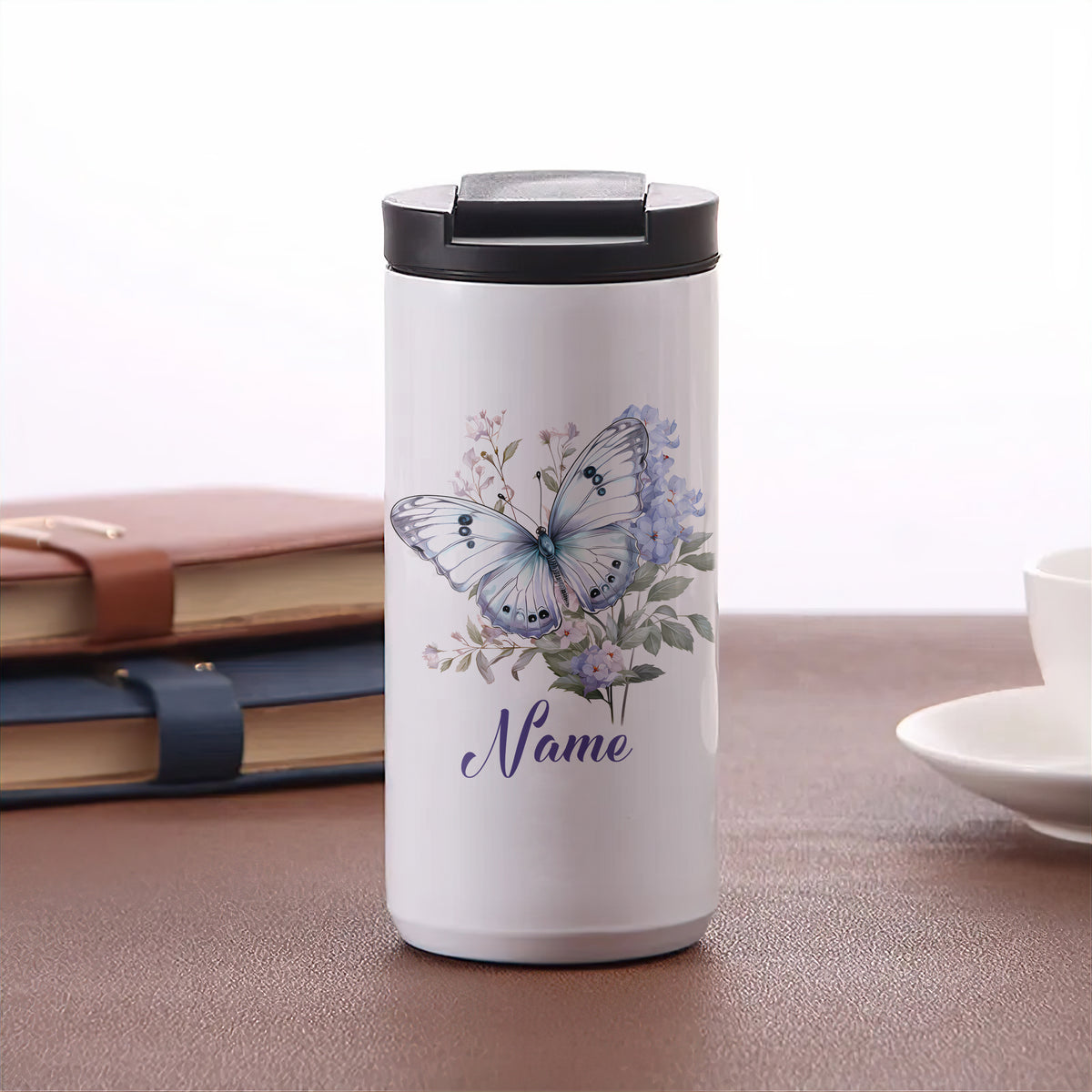 Weißer Thermobecher mit Schmetterlingsdesign und personalisiertem Namen.