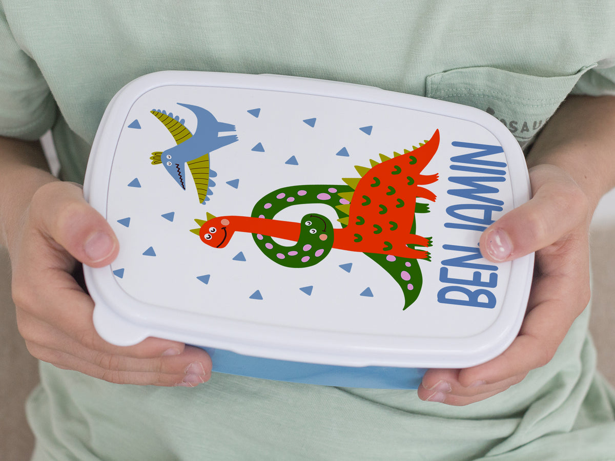 Bunte Brotdose mit Dinosaurier-Motiv und Namen "BENJAMIN".