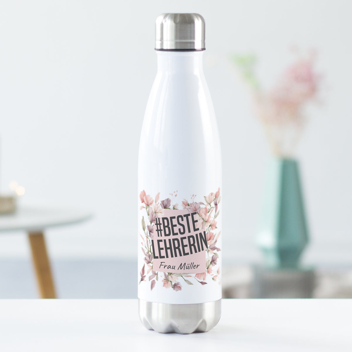 Weiße Edelstahl-Trinkflasche mit floralem Design und Aufschrift.