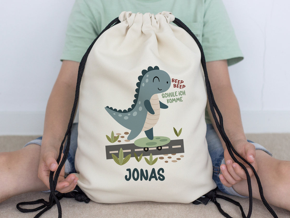Beiger Rucksack mit Dinosaurier-Motiv und Name Jonas.