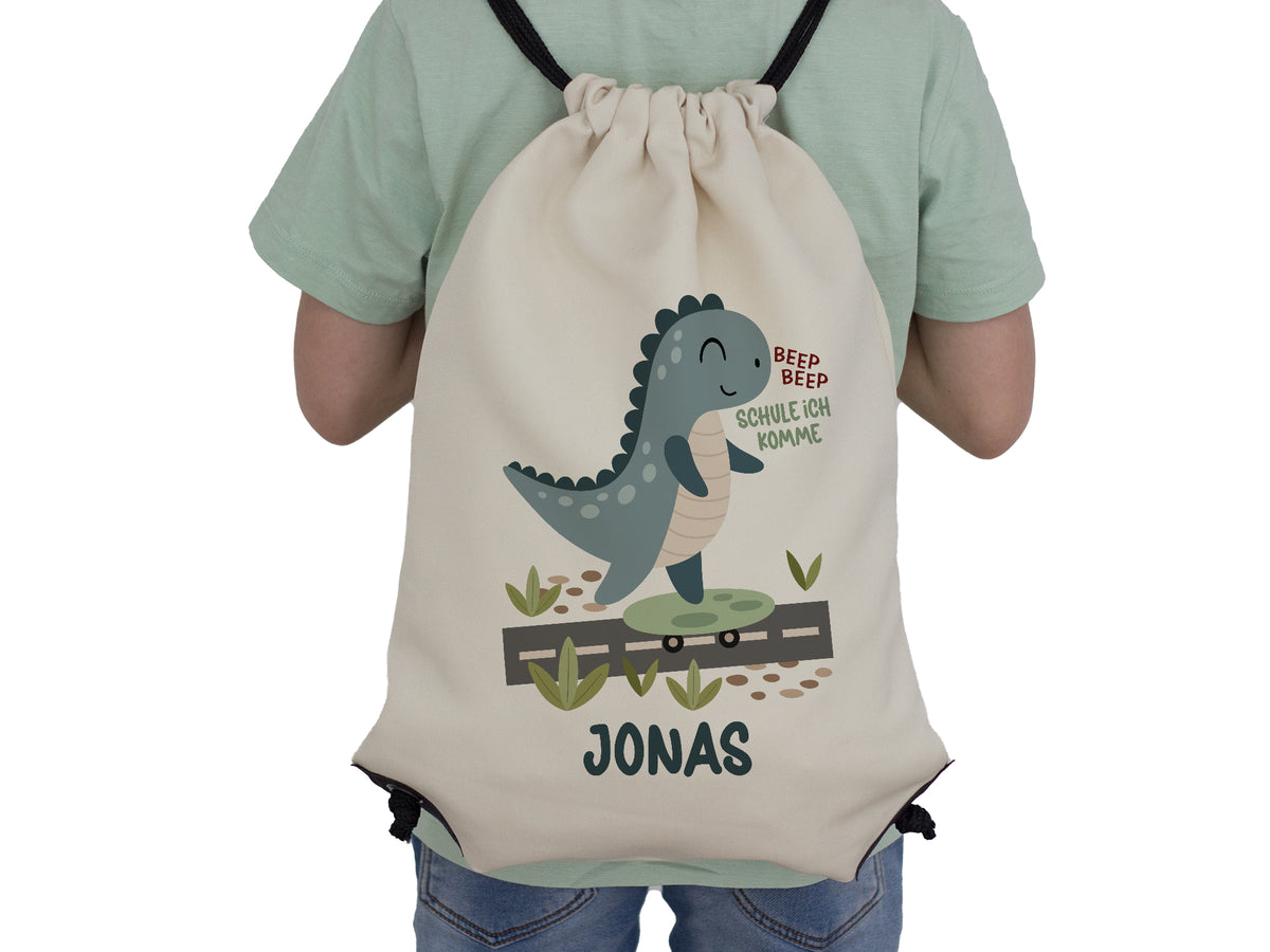 Beige Rucksack mit Dinosaurier-Motiv und Namen Jonas.