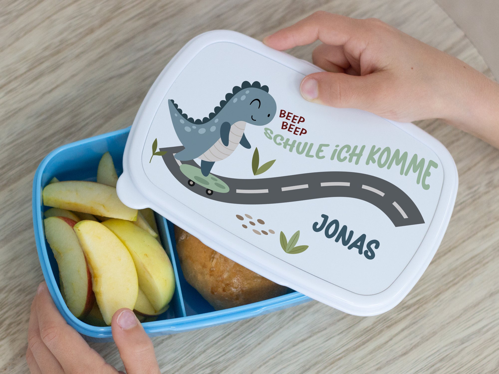 Bunte Lunchbox mit Dinosaurier-Motiv, personalisiert für Jonas.