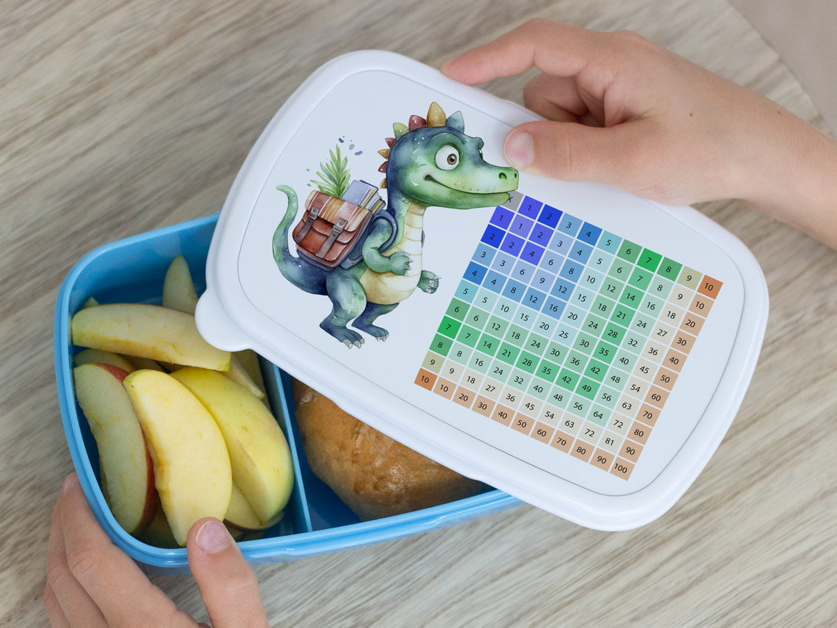 Bunte Brotdose mit Dinosaurier-Motiv und Obst.