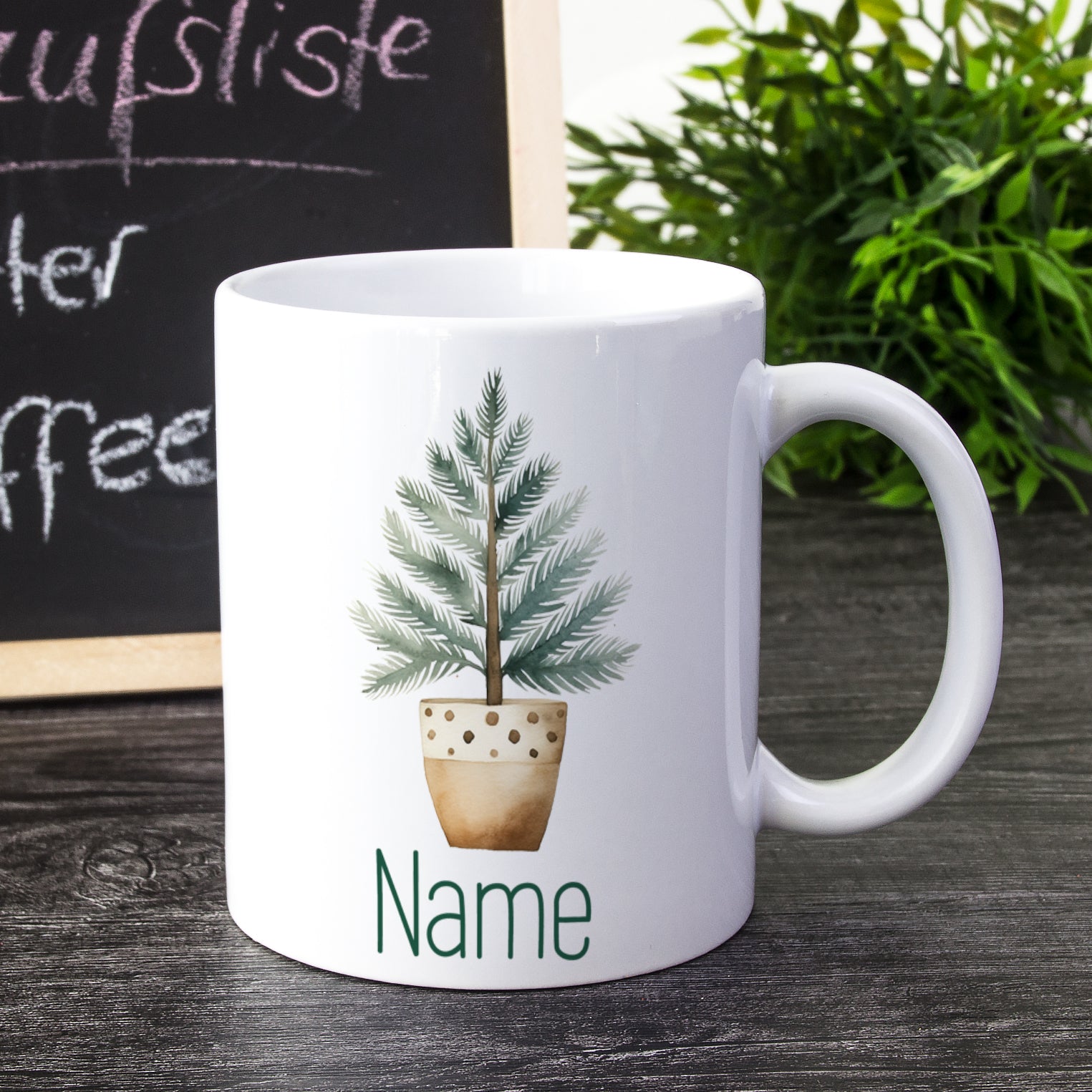 Weiße Tasse mit Pflanze und personalisiertem Namen.