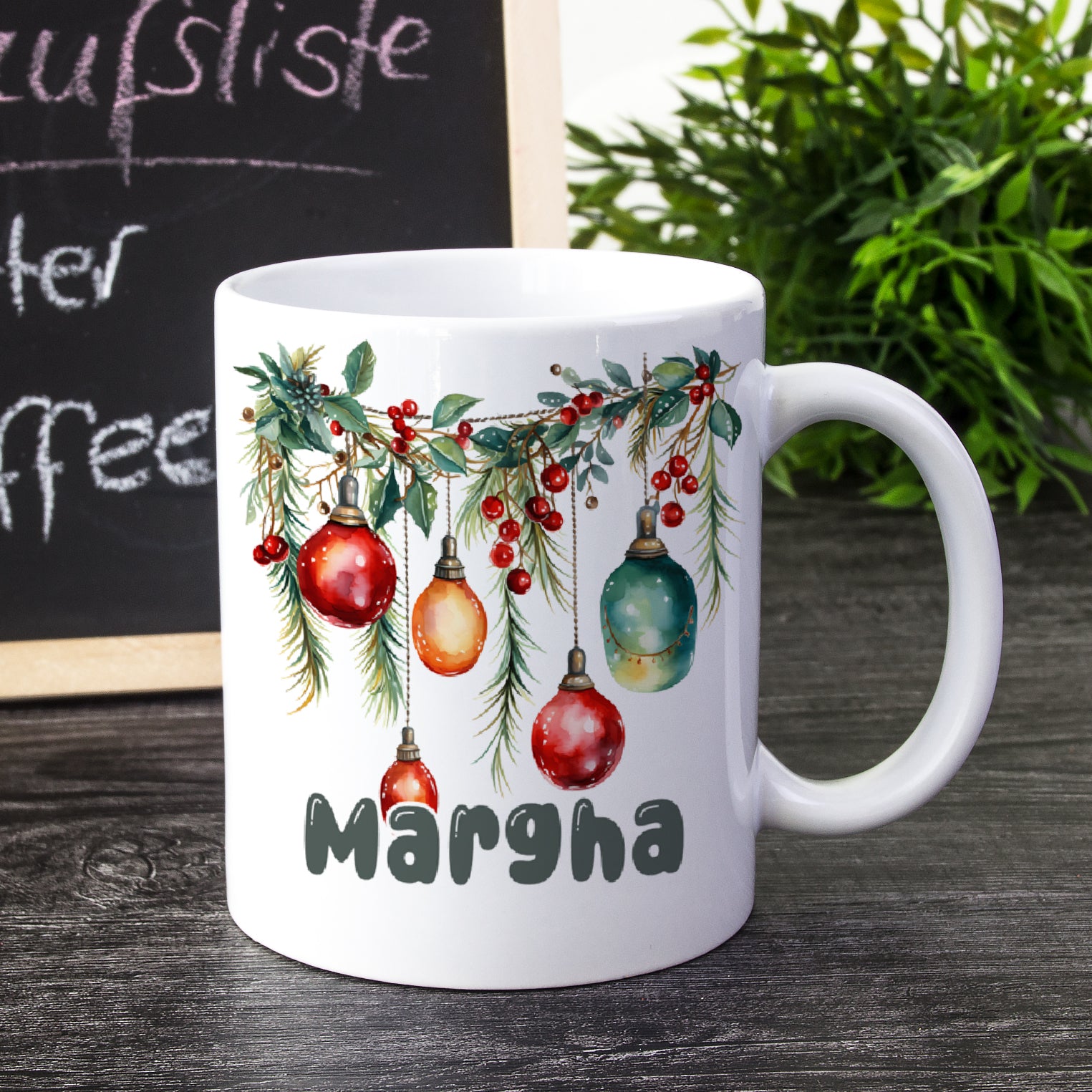 Weißer Kaffeebecher mit Weihnachtsbaumornamenten und dem Namen "Margha".