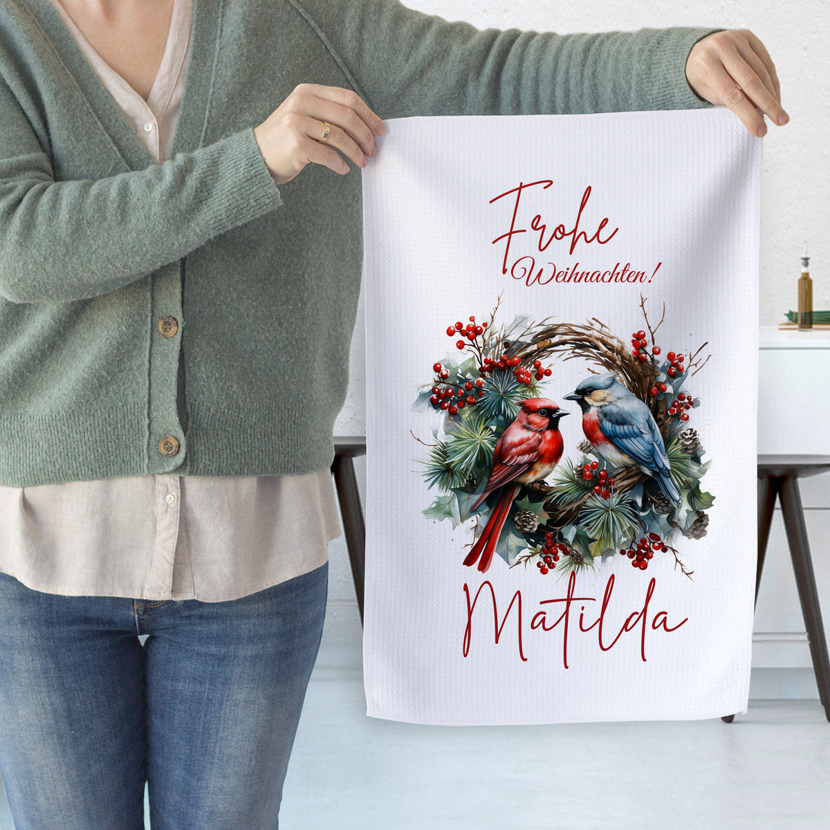 Weihnachtliches Geschirrtuch mit roten und blauen Vögeln.