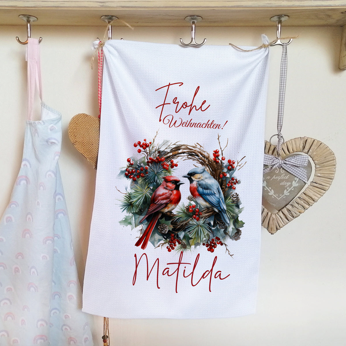 Frohe Weihnachten! Geschirrtuch mit roten und blauen Vögeln.