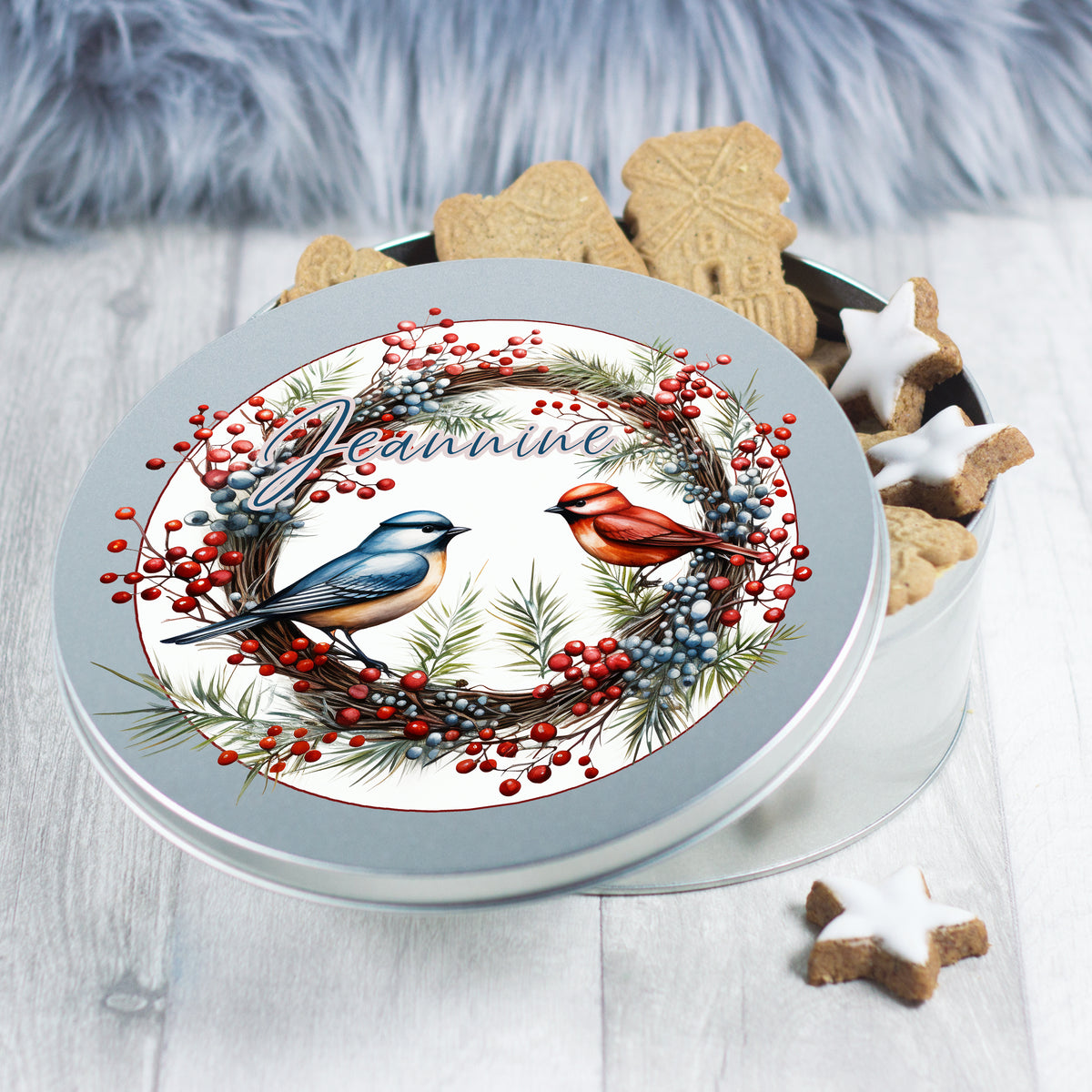 Runde Blechdose mit Vögeln und Weihnachtskranz-Motiv.