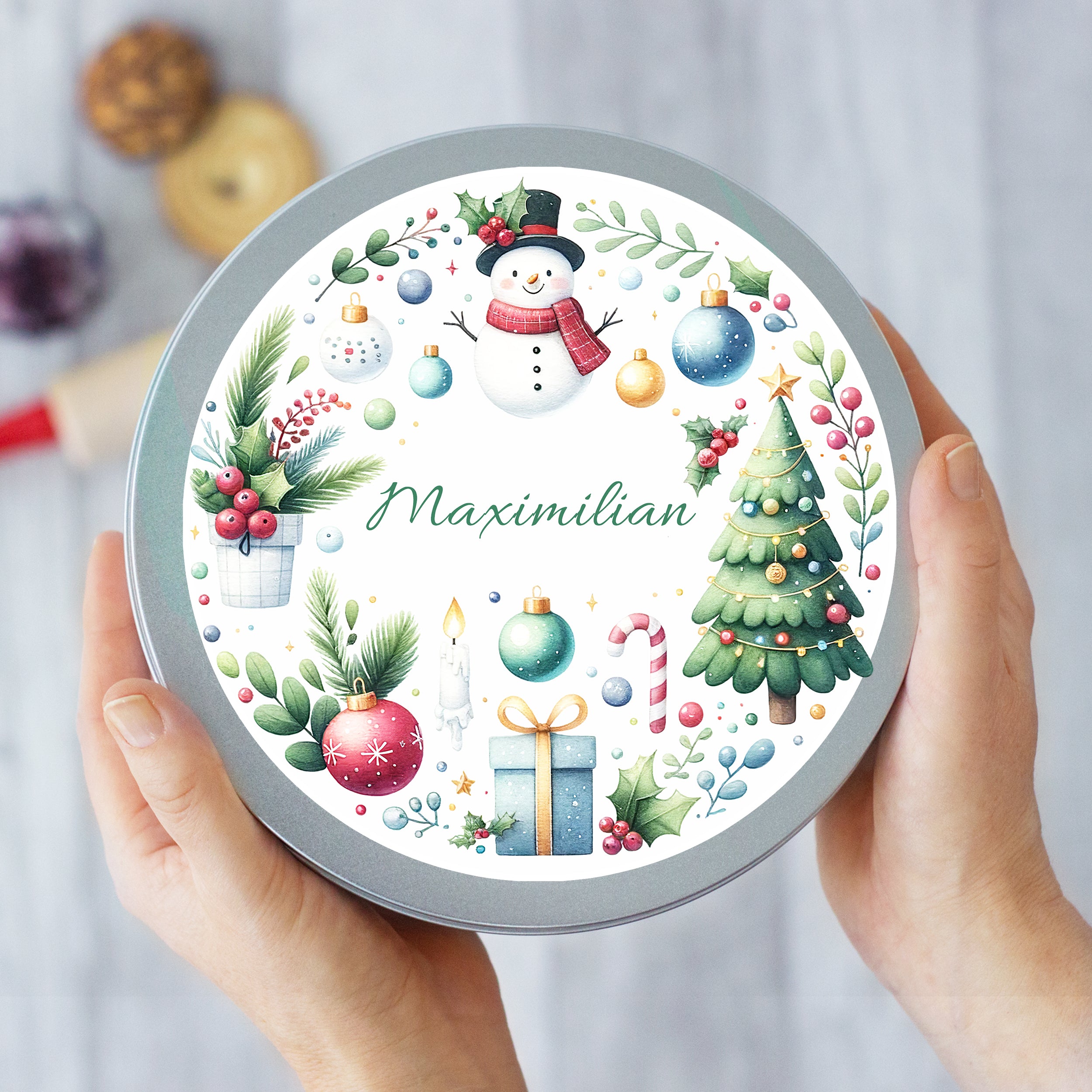 Weihnachtliche Metalldose mit personalisiertem Namen, bunt verziert.
