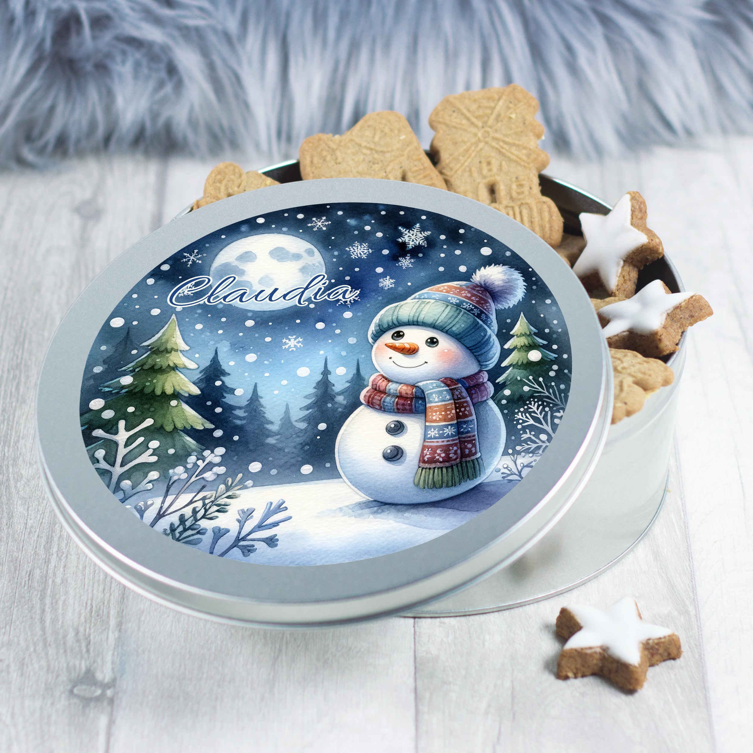 Runde Keksdose mit Schneemann-Motiv und Weihnachtsgebäck.