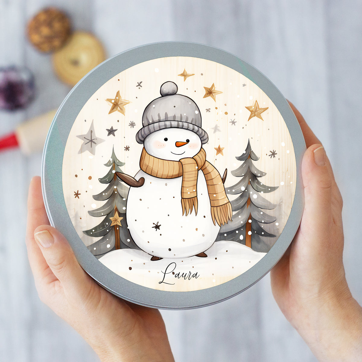 Runde Blechdose mit Schneemann, grauer Mütze und braunem Schal.