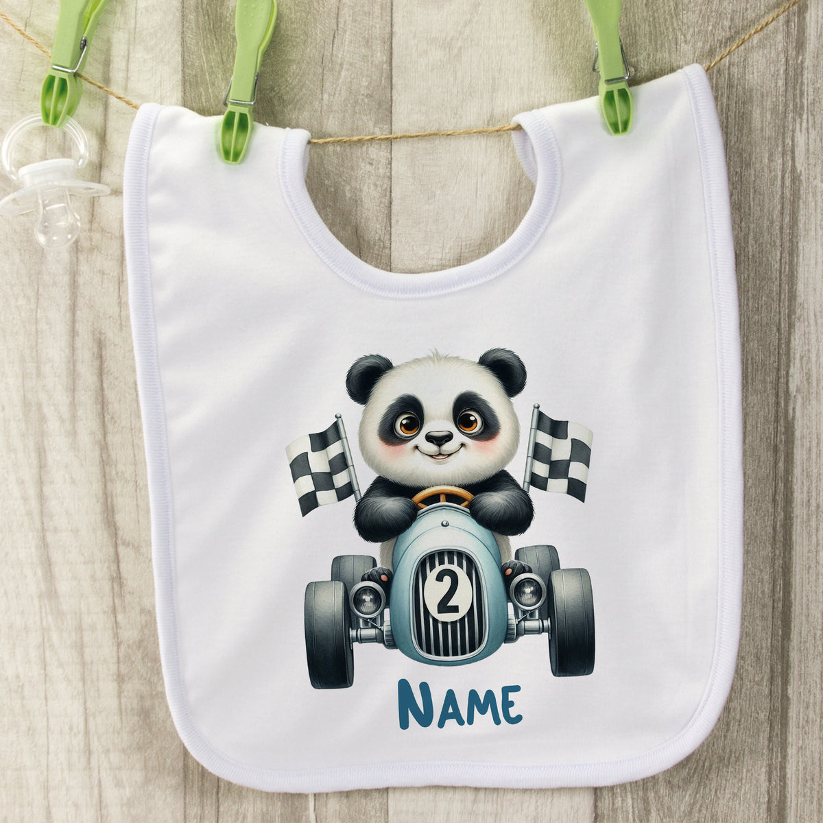 Weißes Baby-Lätzchen mit panda-fahrendem Rennwagen und Flaggen.