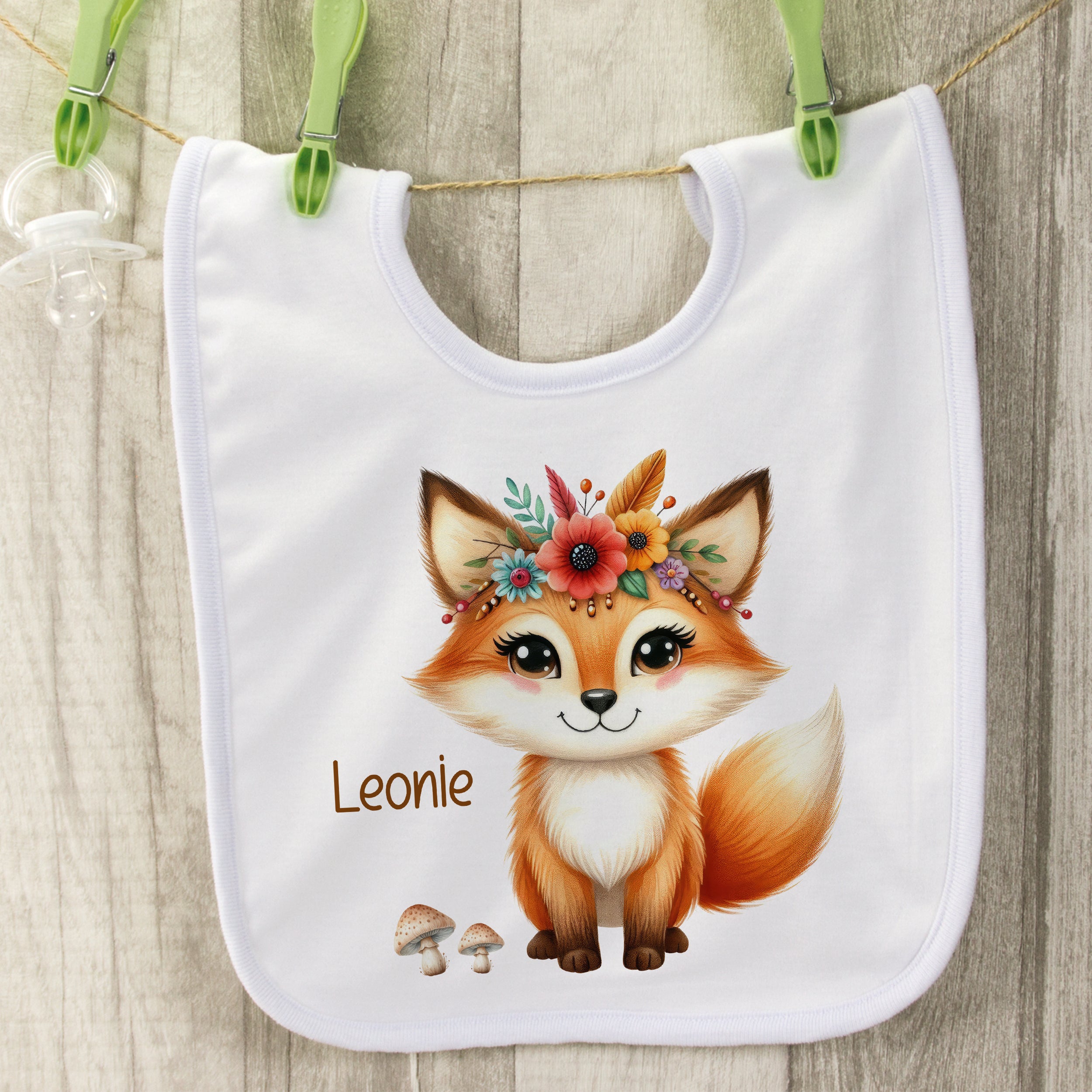 Weißes Lätzchen mit Fuchs-Motiv und Blumenkranz.