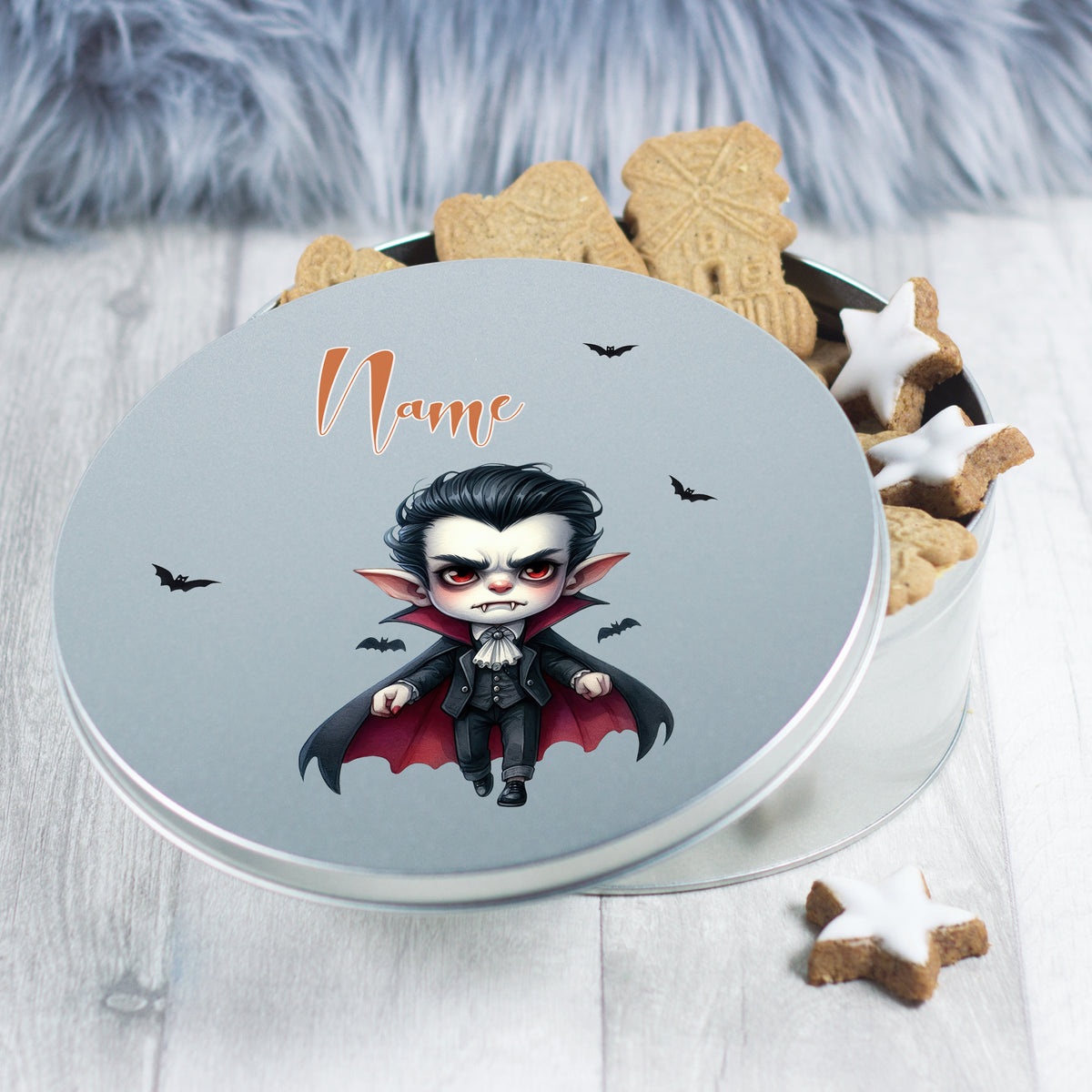 Runde Blechdose mit Vampir-Motiv und Keksen.