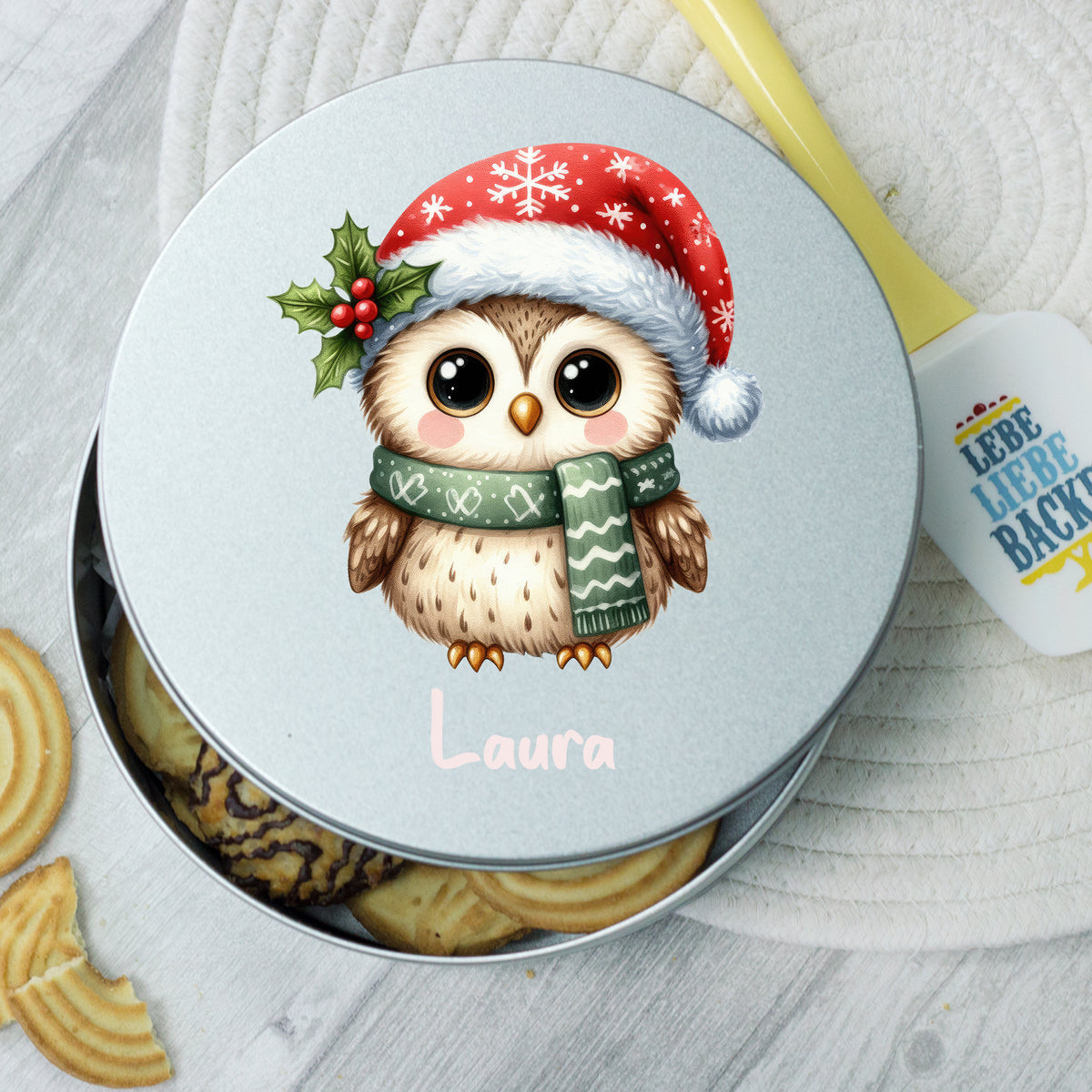 Eule mit Weihnachtsmütze auf silberner Keksdose, personalisiert.