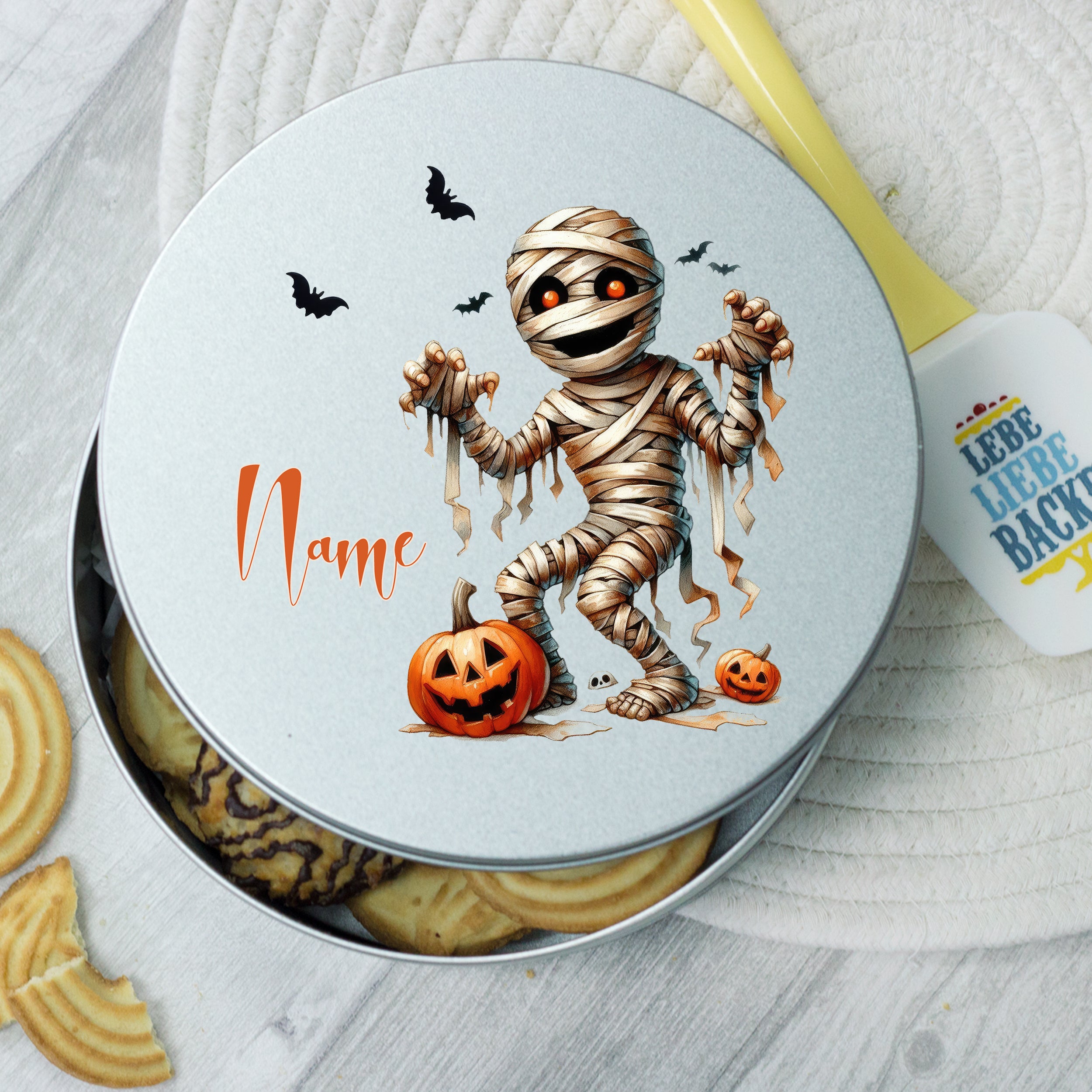 Mumien-Dose mit Halloween-Motiv und Kürbis, silberfarben.