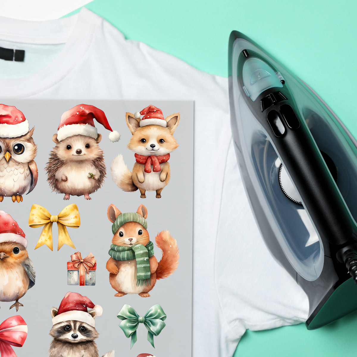 Weißes T-Shirt mit niedlichen Weihnachts-Tiermotiven und Bügeleisen.