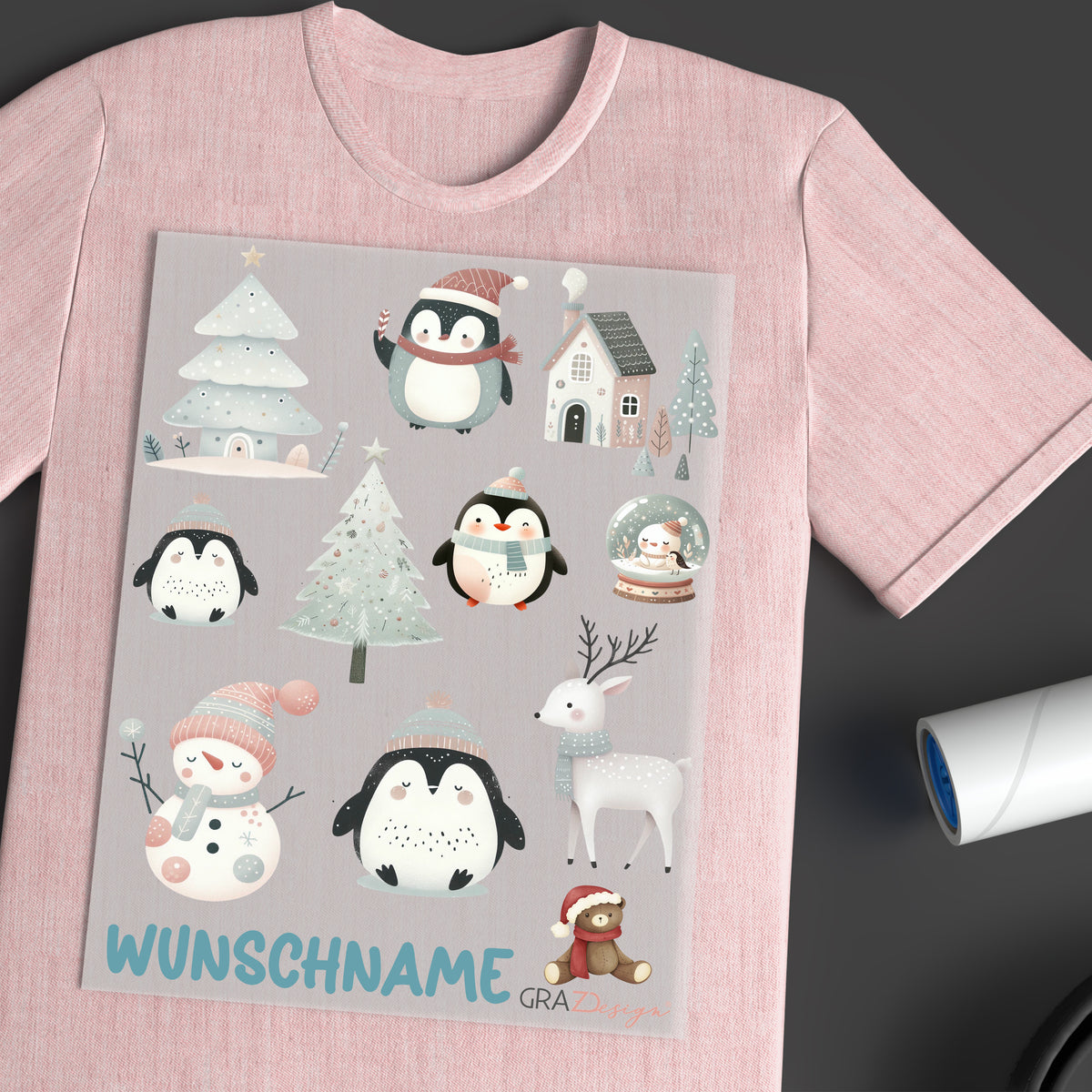 Rosa T-Shirt mit winterlichen Pinguin-Motiven und Text.