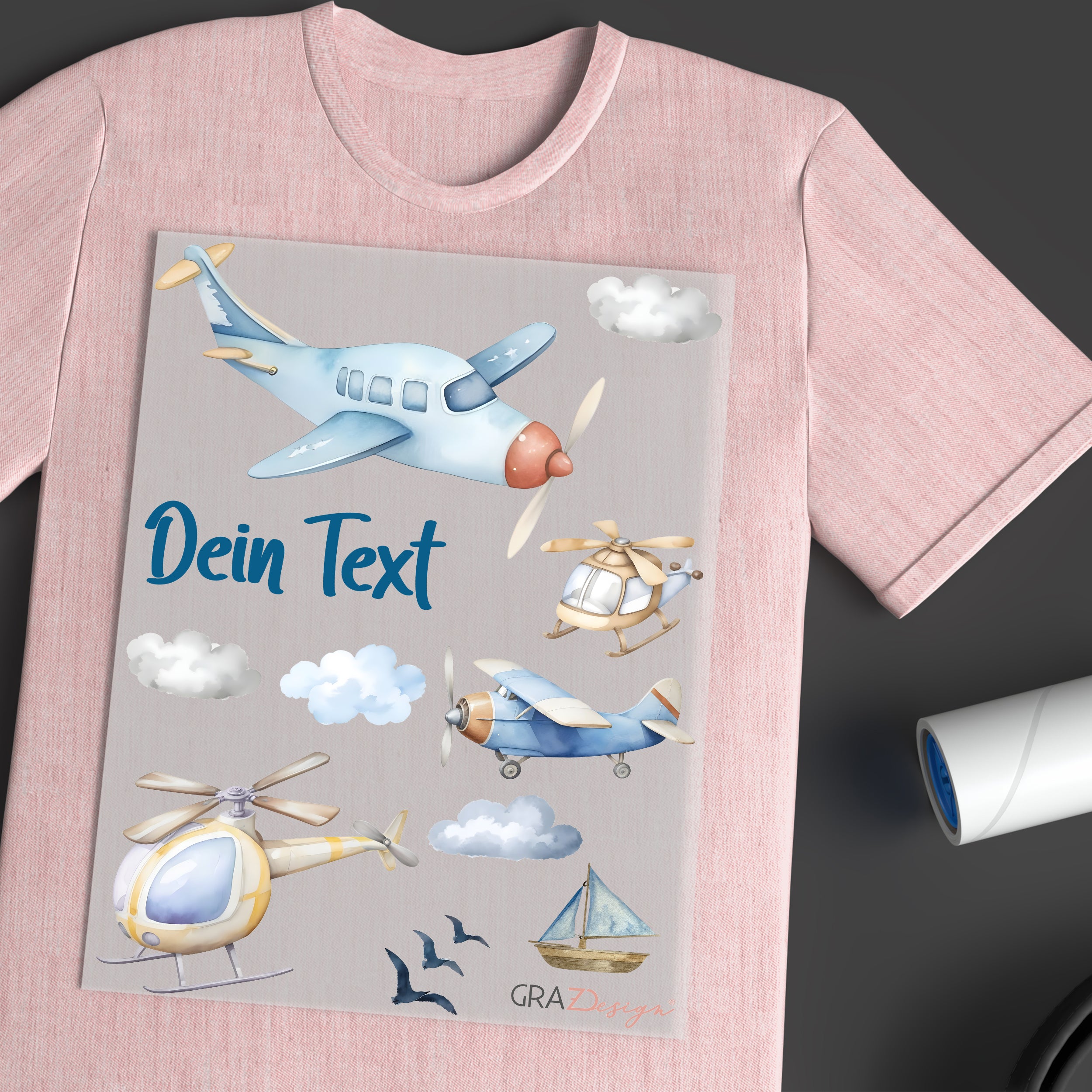 Rosa T-Shirt mit Flugzeugen, Wolken und personalisiertem Text.