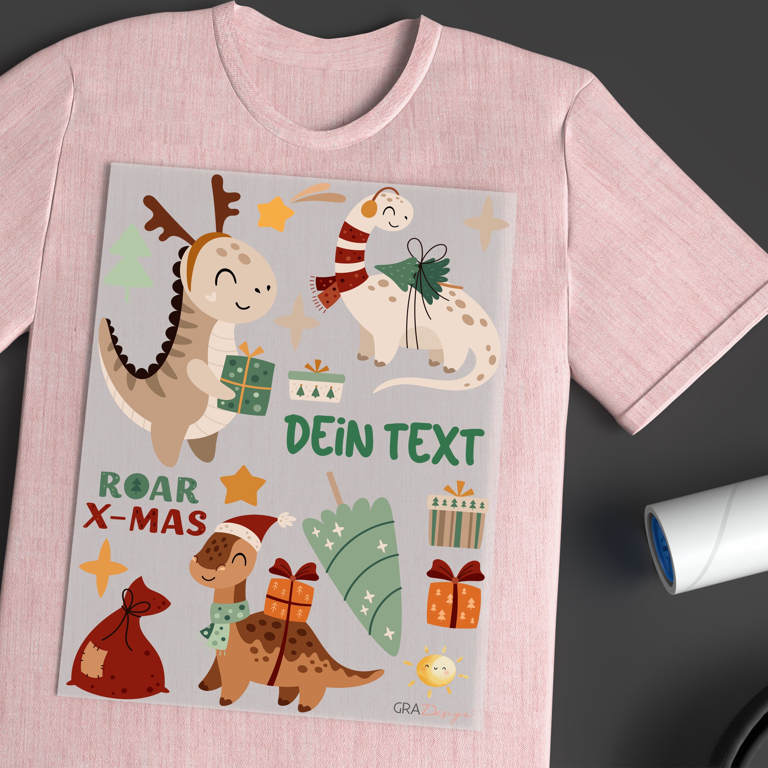 Rosa T-Shirt mit Dinosauriern und Weihnachtsmotiven.