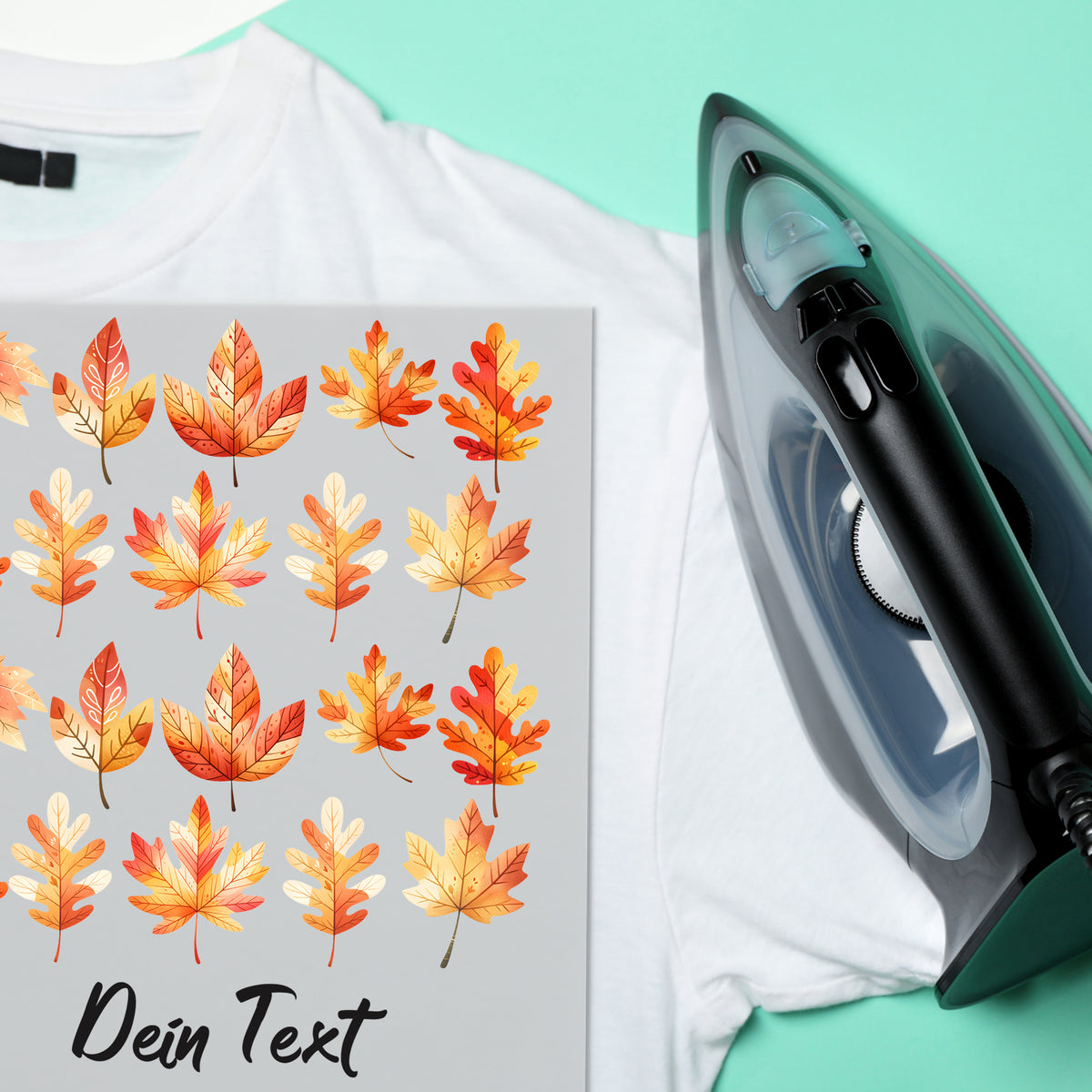 Weißes T-Shirt mit bunten Herbstblättern und Bügeleisen.