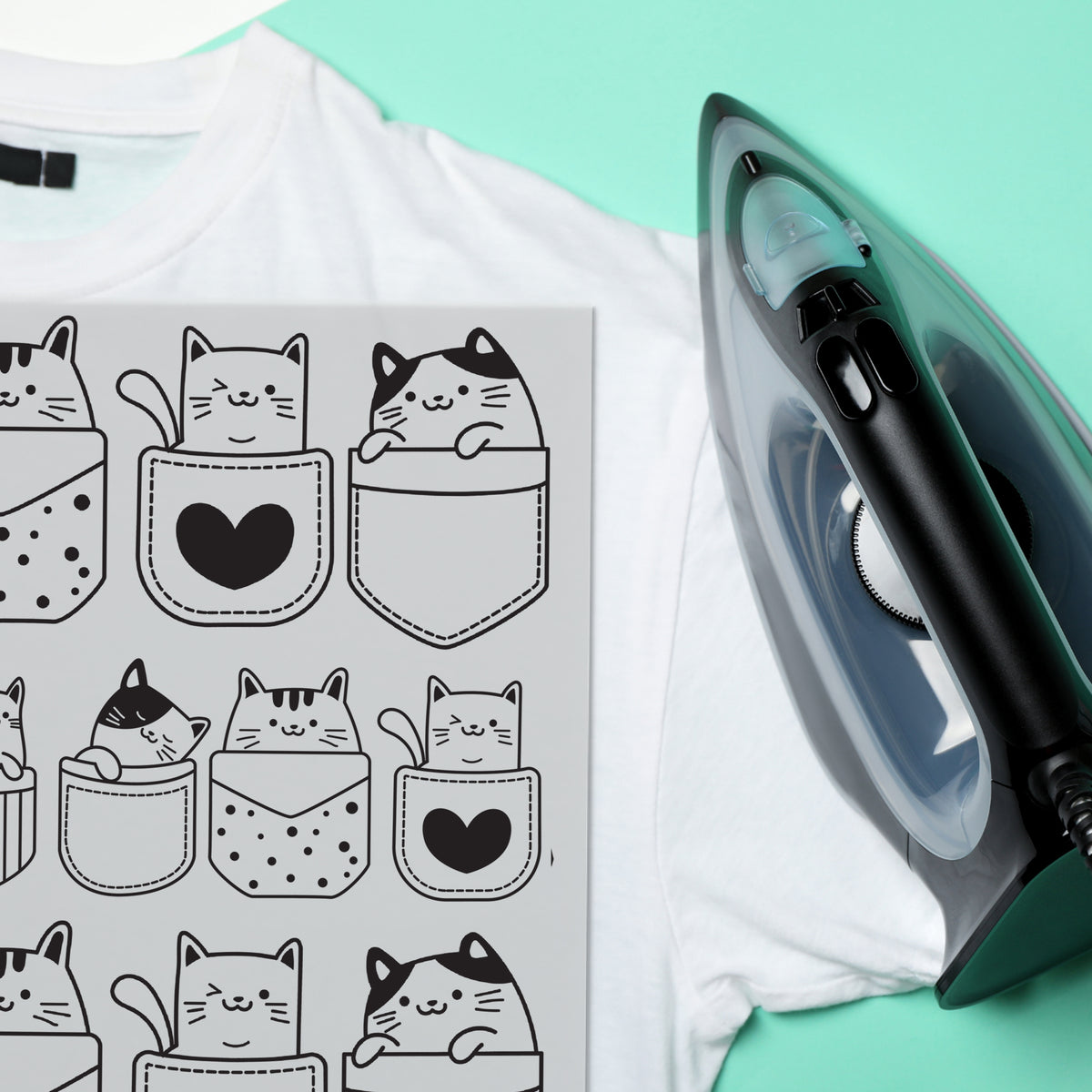 Weißes T-Shirt mit Katzenmuster und schwarzem Bügeleisen.