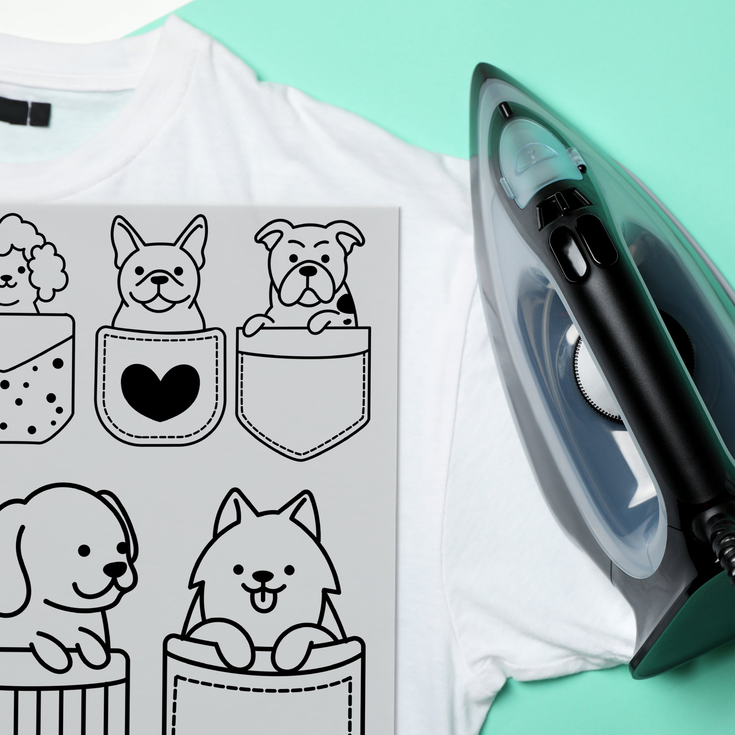 Weißes T-Shirt mit Hundemotiven und schwarzem Bügeleisen.