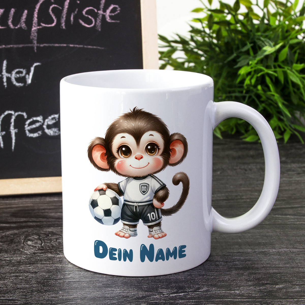Weißer Kaffeebecher mit niedlichem Fußballaffen und personalisiertem Namen.