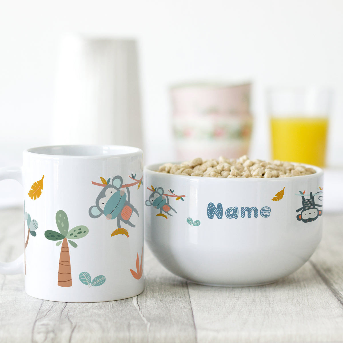 Tasse und Schüssel mit bunten Tiermotiven und personalisiertem Namen.