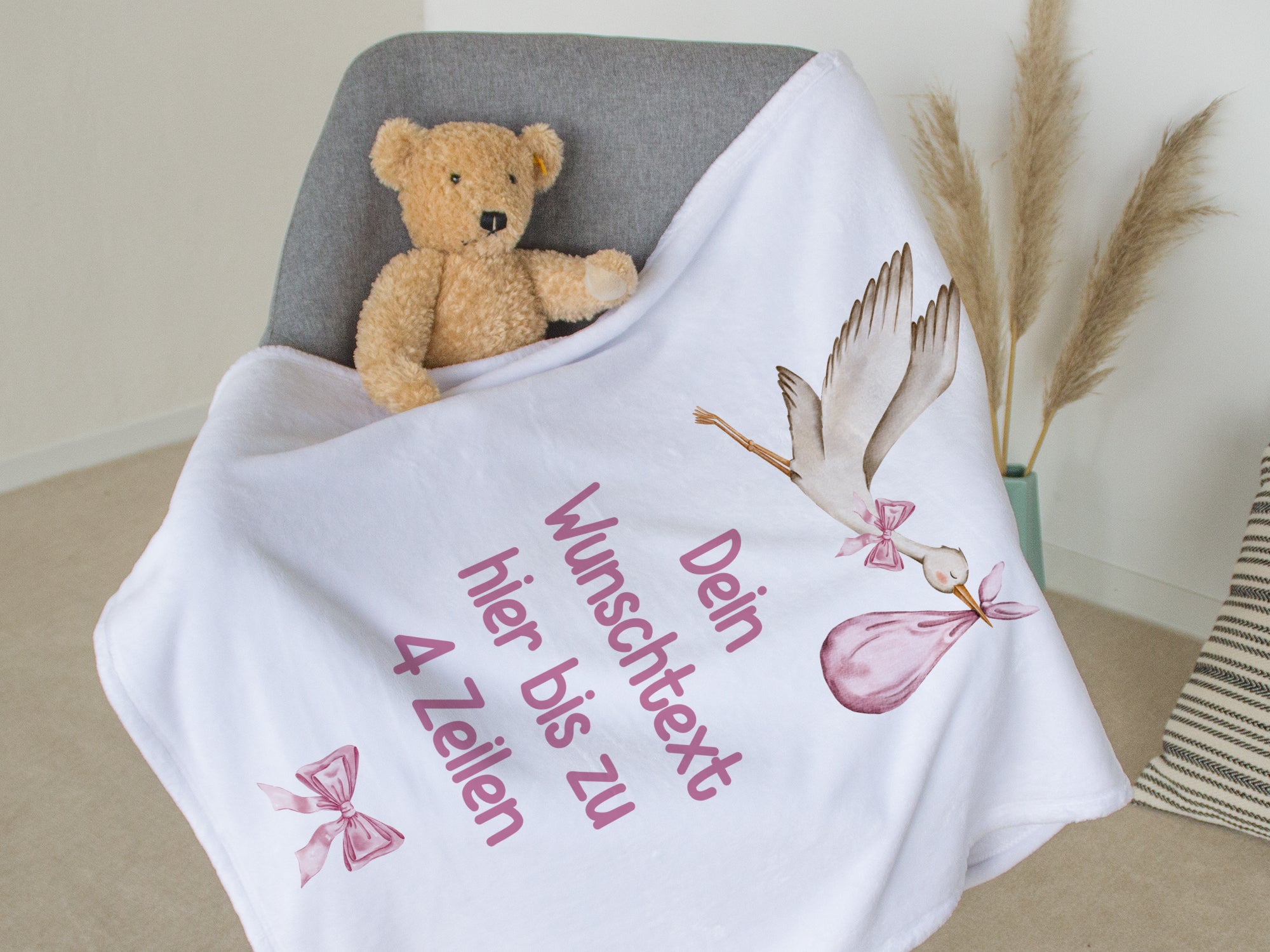 Weiße Decke mit personalisierbarem Text und Storch-Motiv.