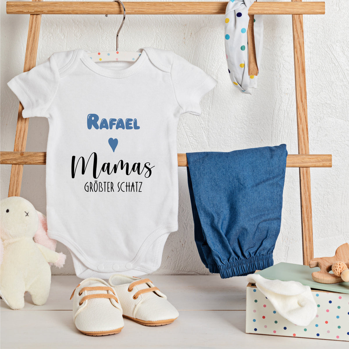 Weißes Babybody mit blauem Text, "Rafael Mamás größter Schatz".