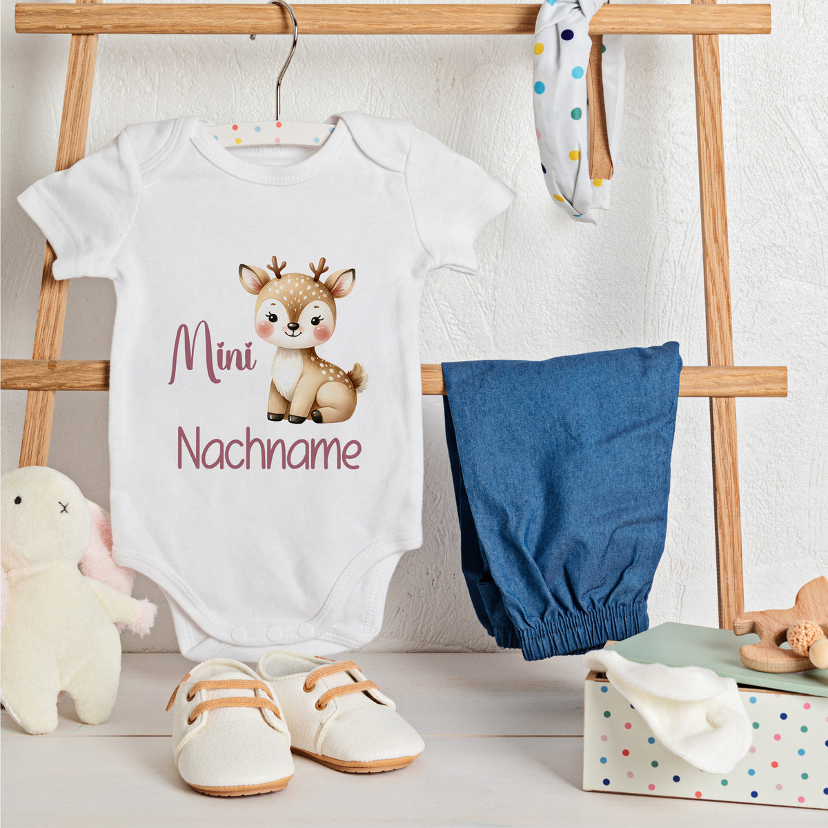 Weißes Babybody mit Reh-Motiv und personalisierbarem Text.