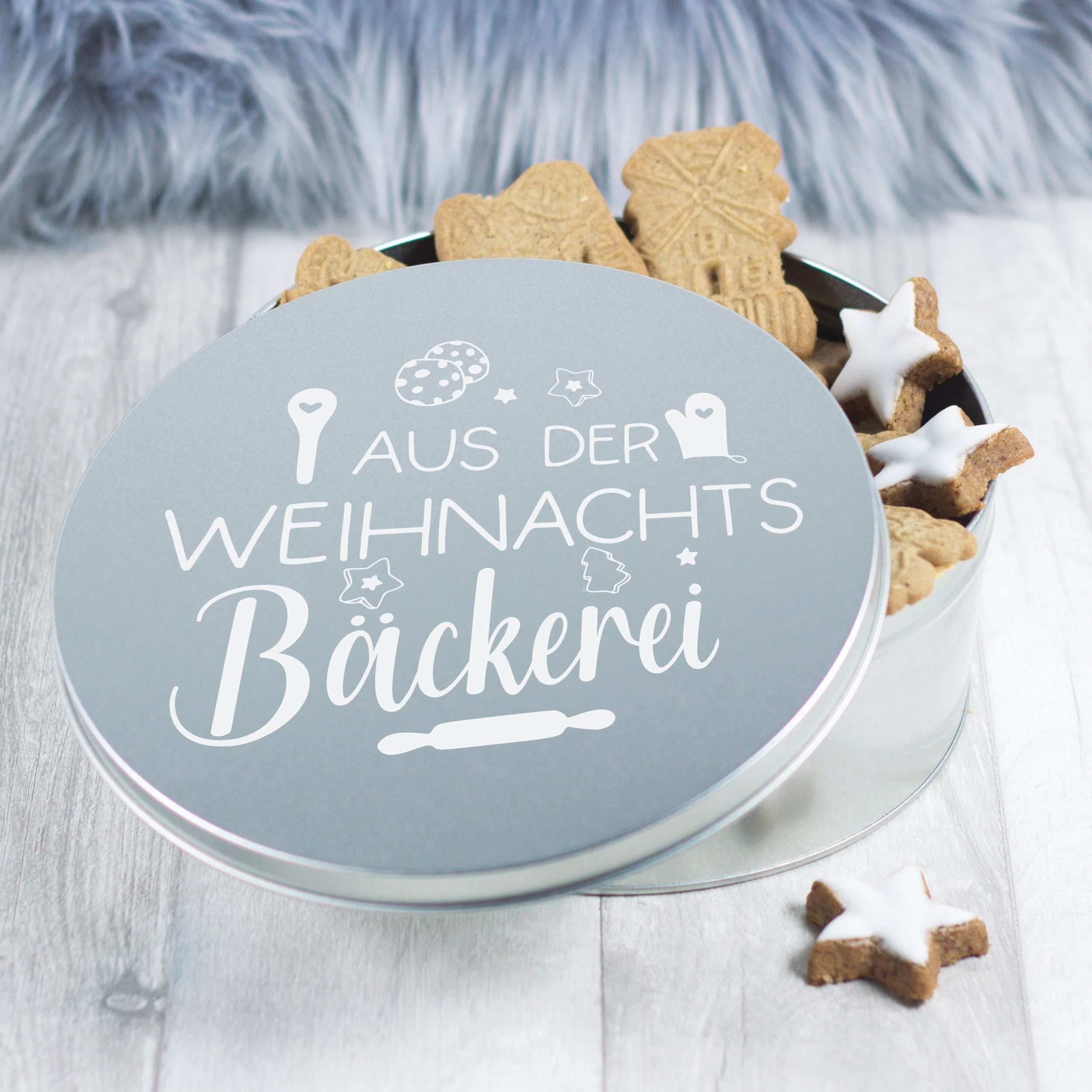 Blechdose mit Weihnachtsplätzchen und dekorativem Aufdruck.