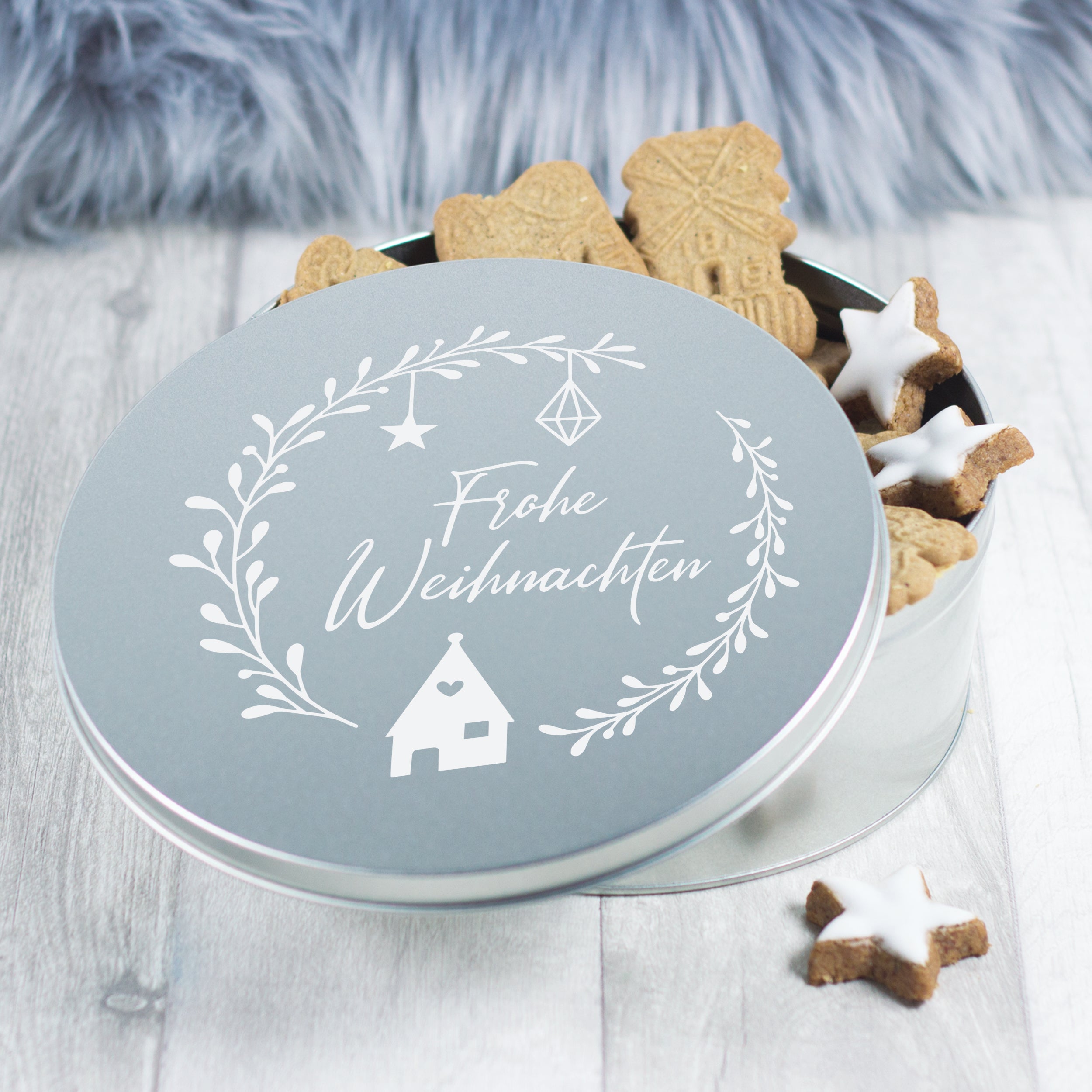 Silberne Weihnachtsdose mit Plätzchen und Dekoration.